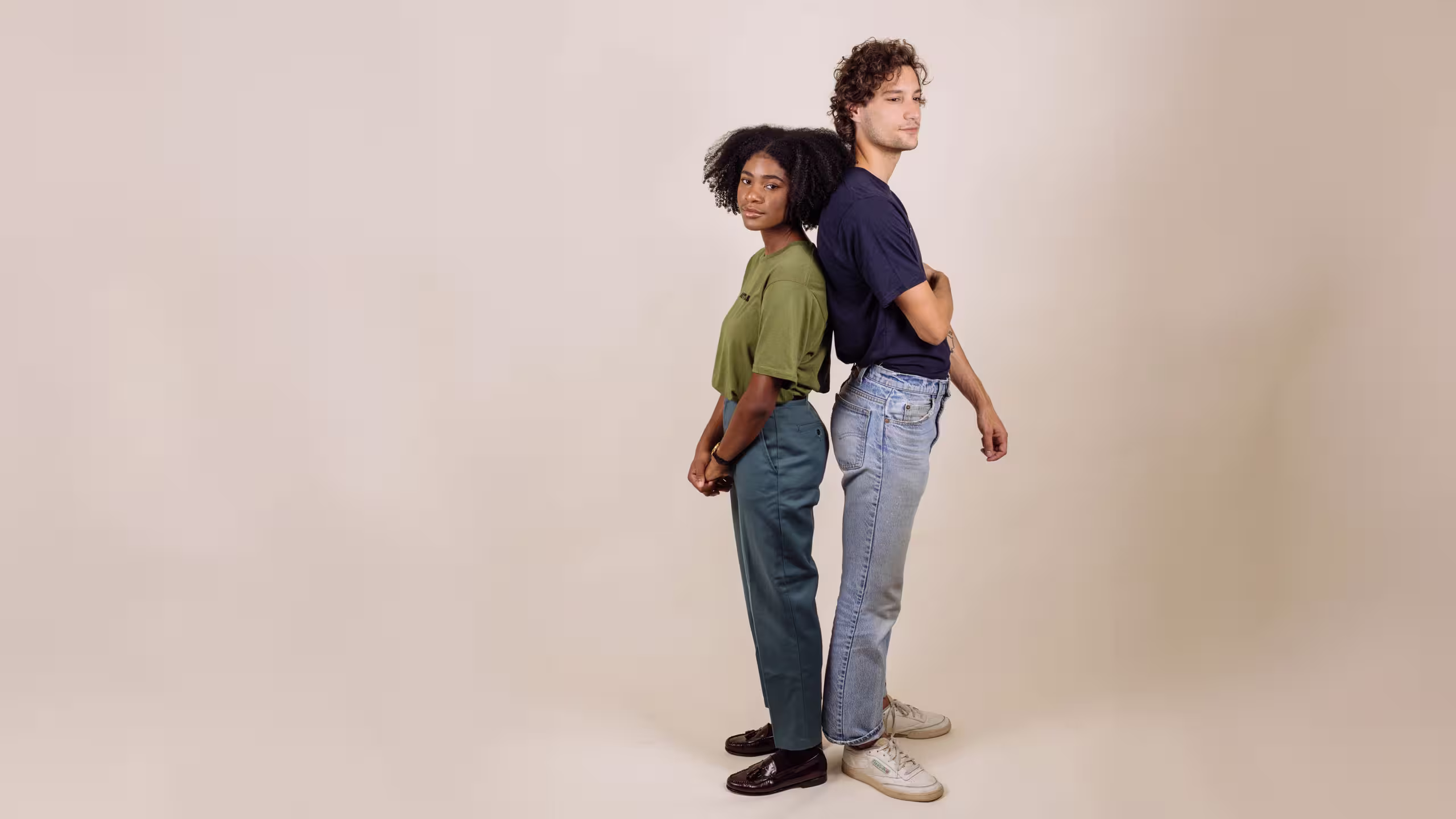 man and a female standing back-to-back in front of a white background