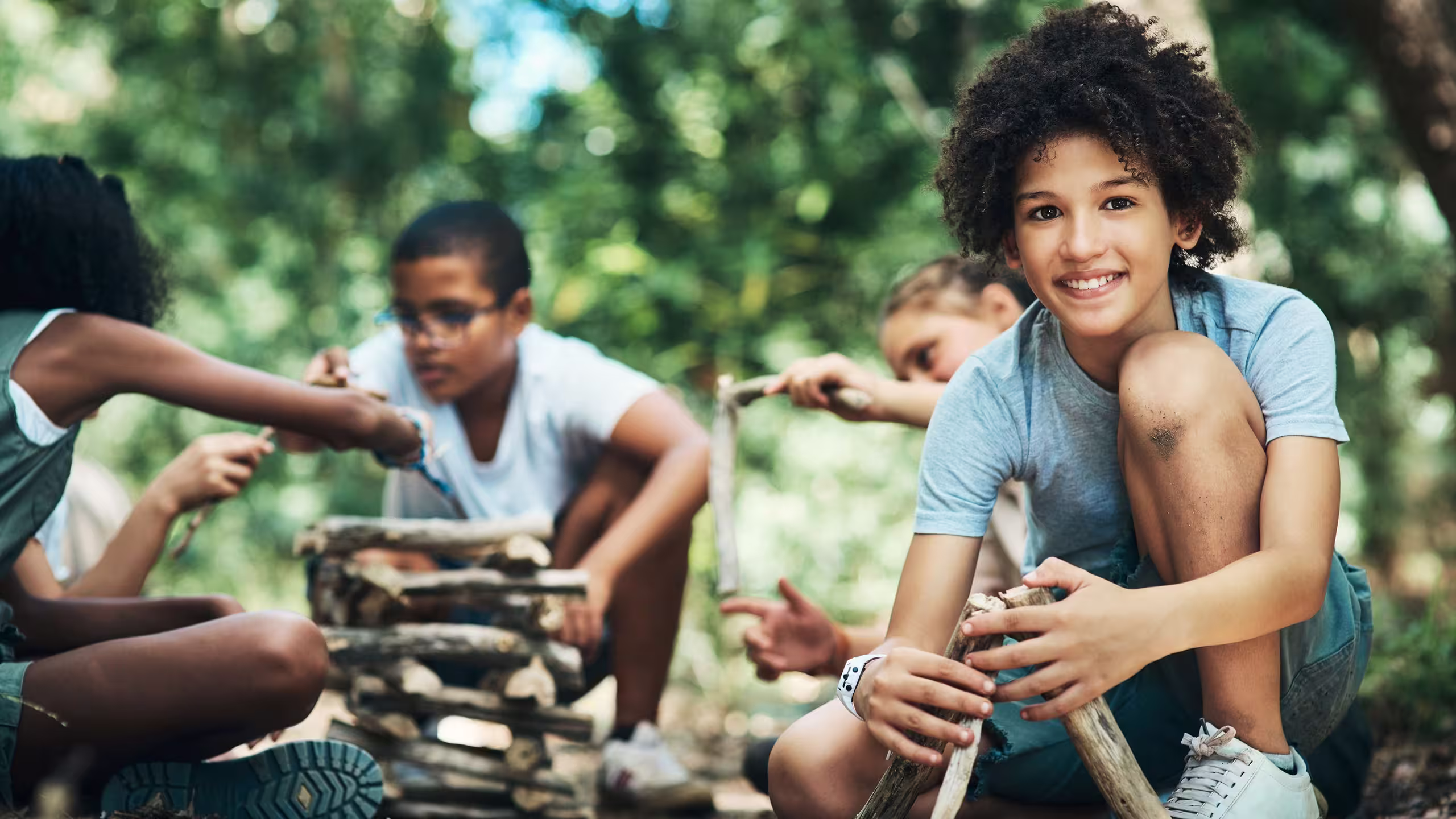 several kids building camp fires