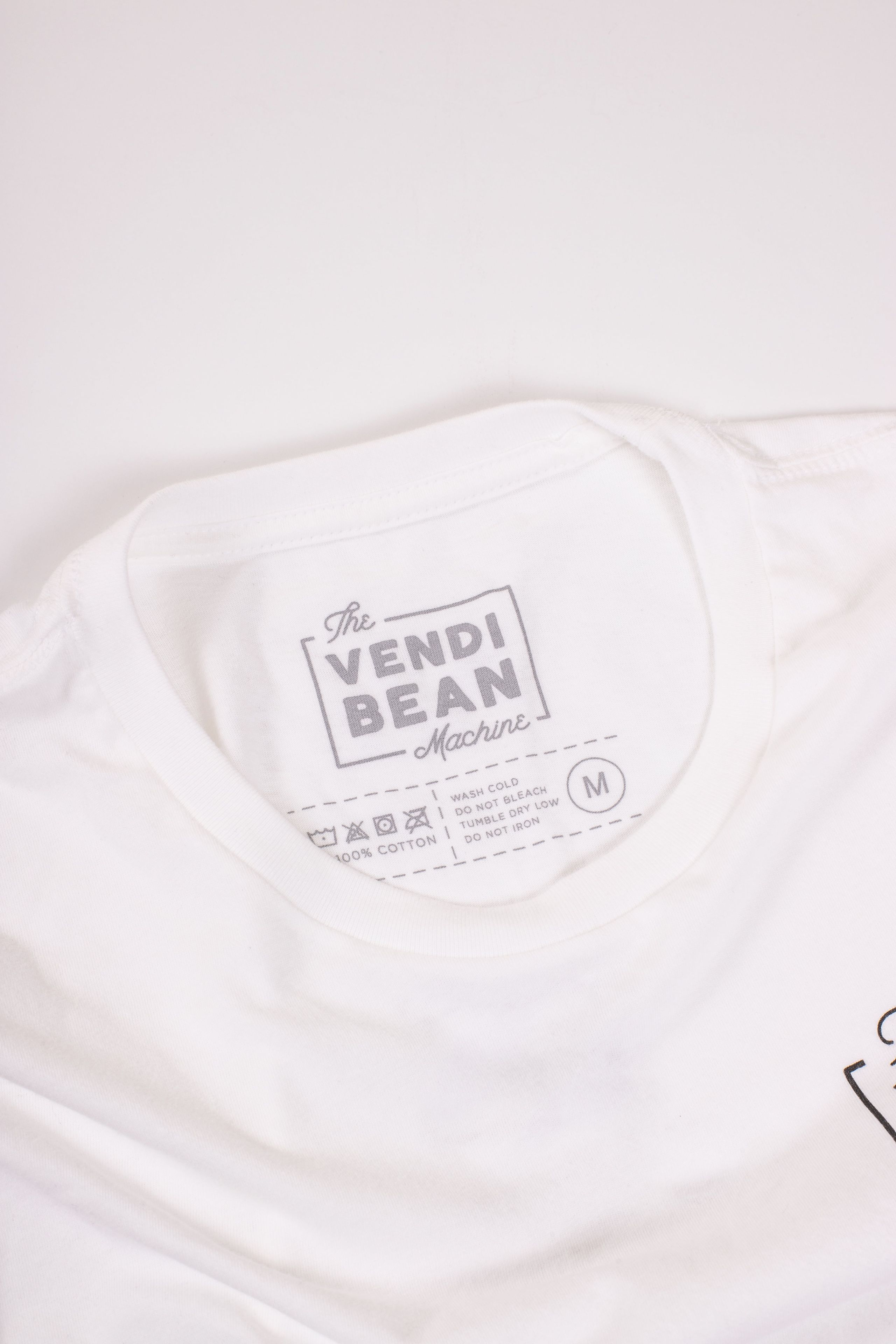 A custom printed tag for the Vendi Bean Machine on a white shirt 