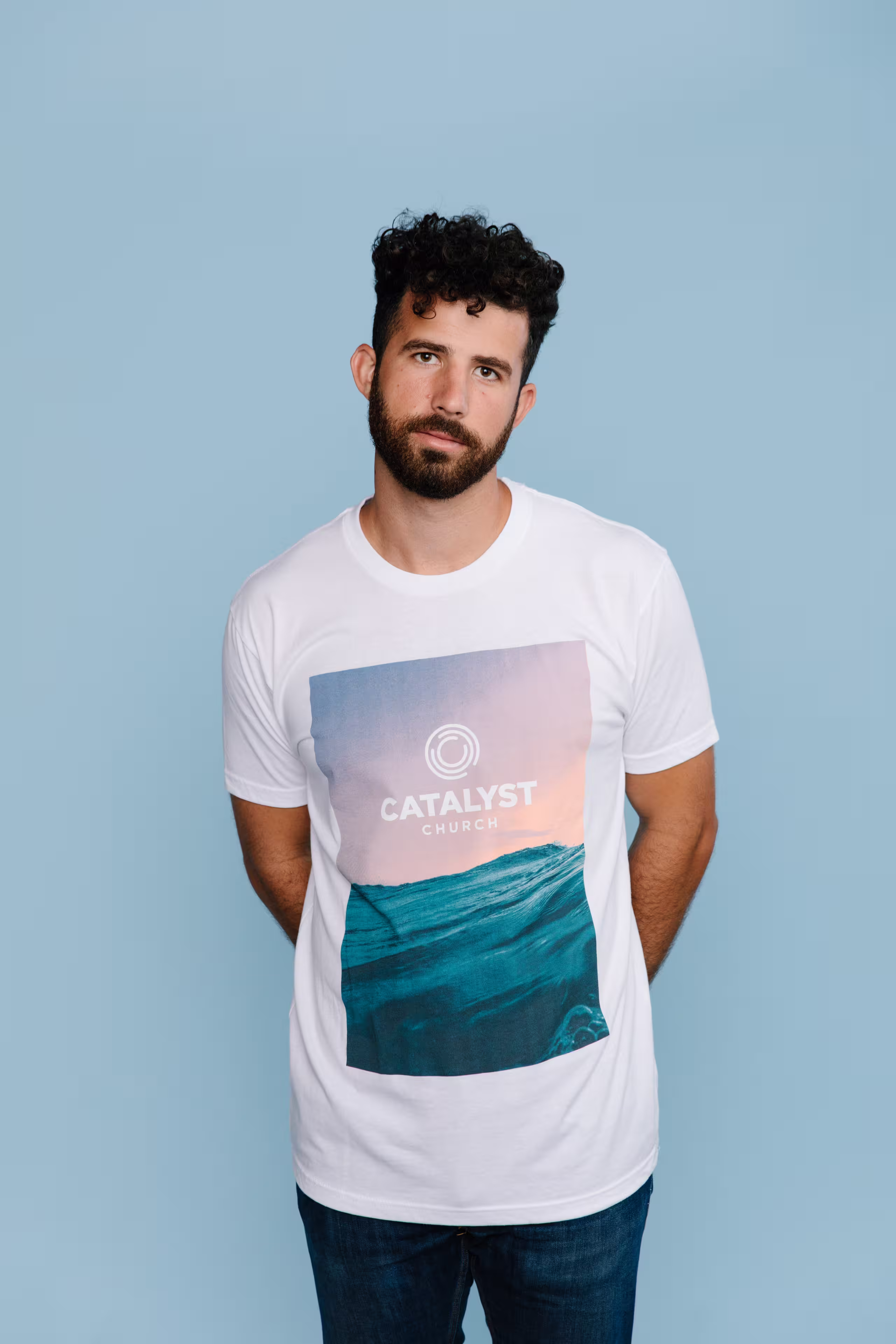 man wearing a white shirt with an image of an ocean printed on it