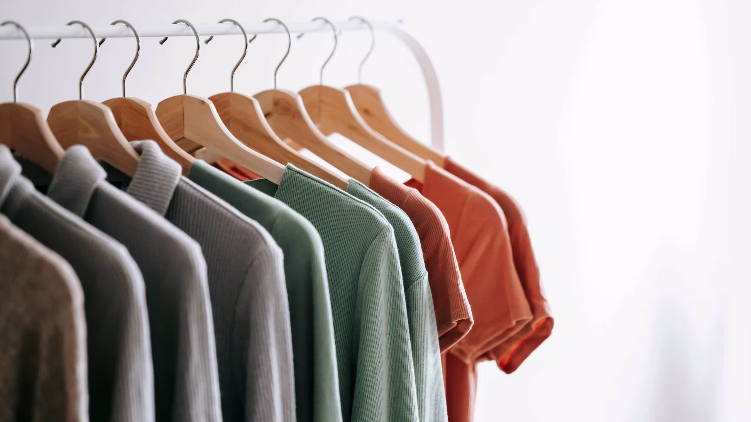 several shirts hanging on a white rack