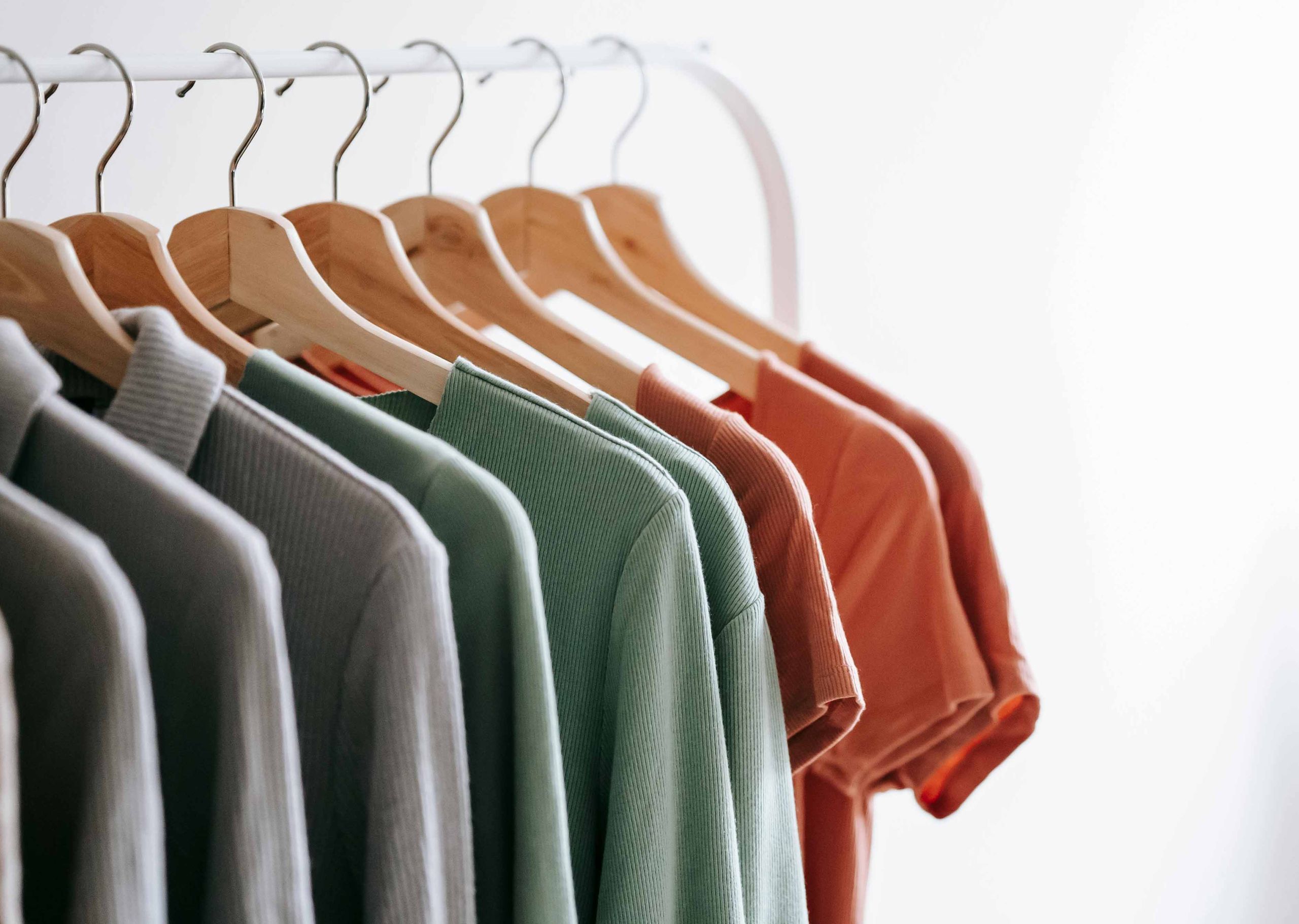 several shirts hanging on a white rack
