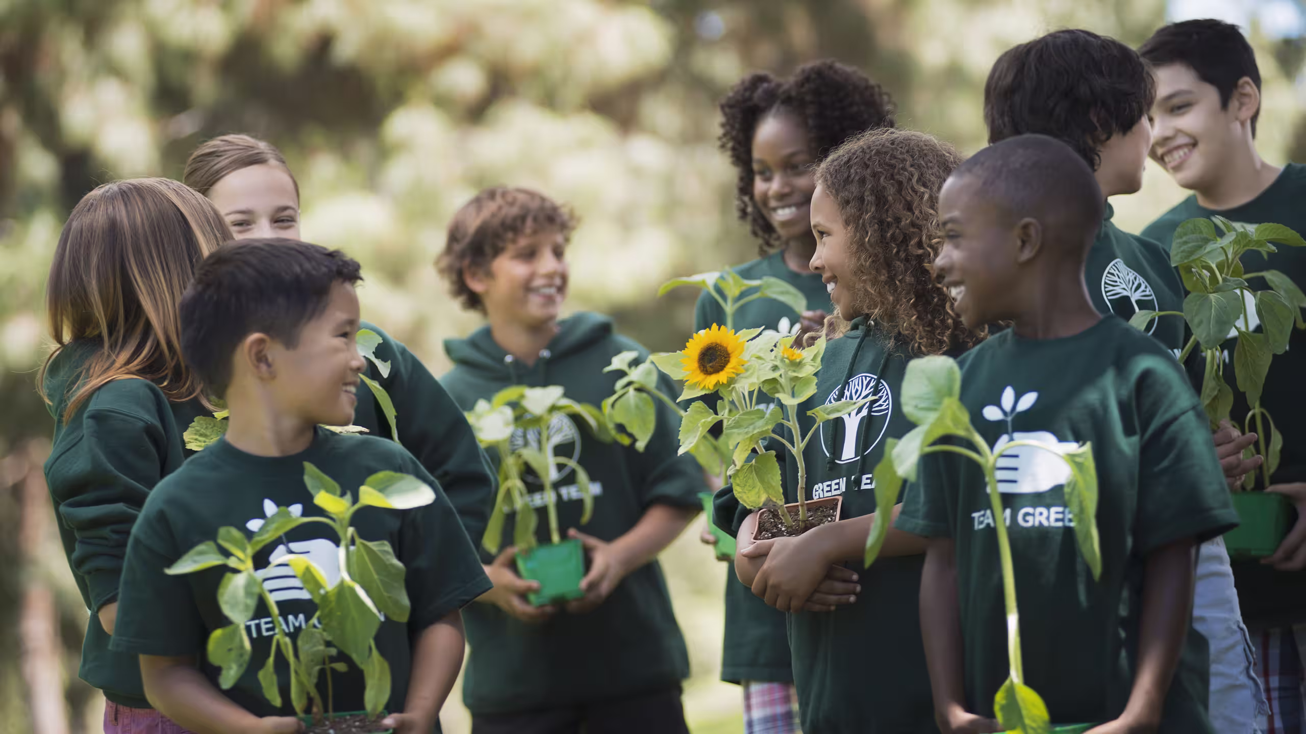 a group of kids in green t-shirts and hoodies