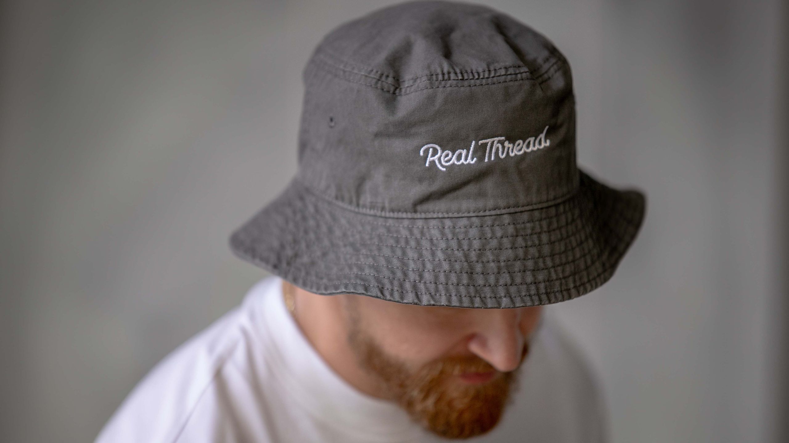 close up of a man wearing an embroidered bucket hat