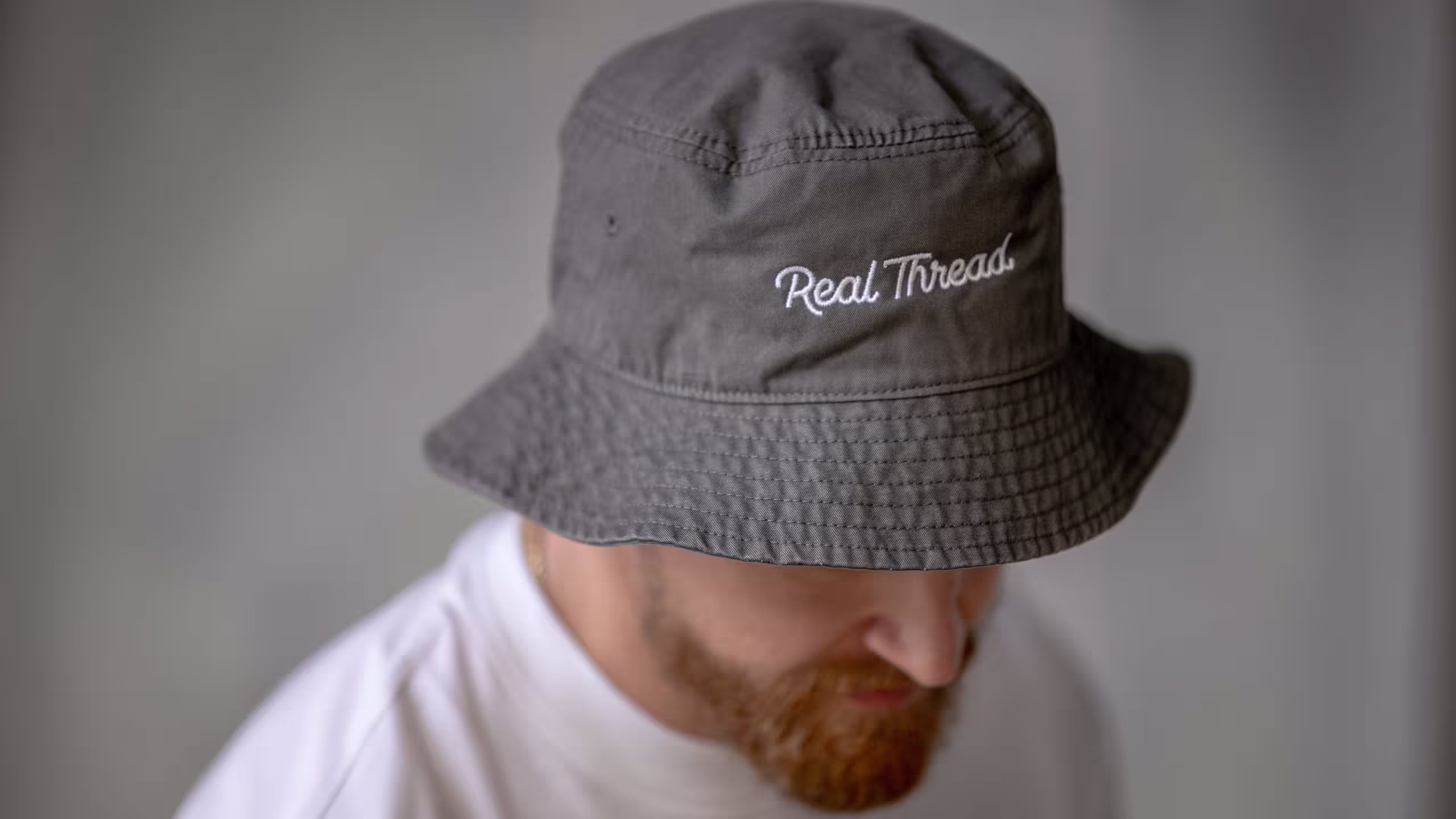 close up of a man wearing an embroidered bucket hat