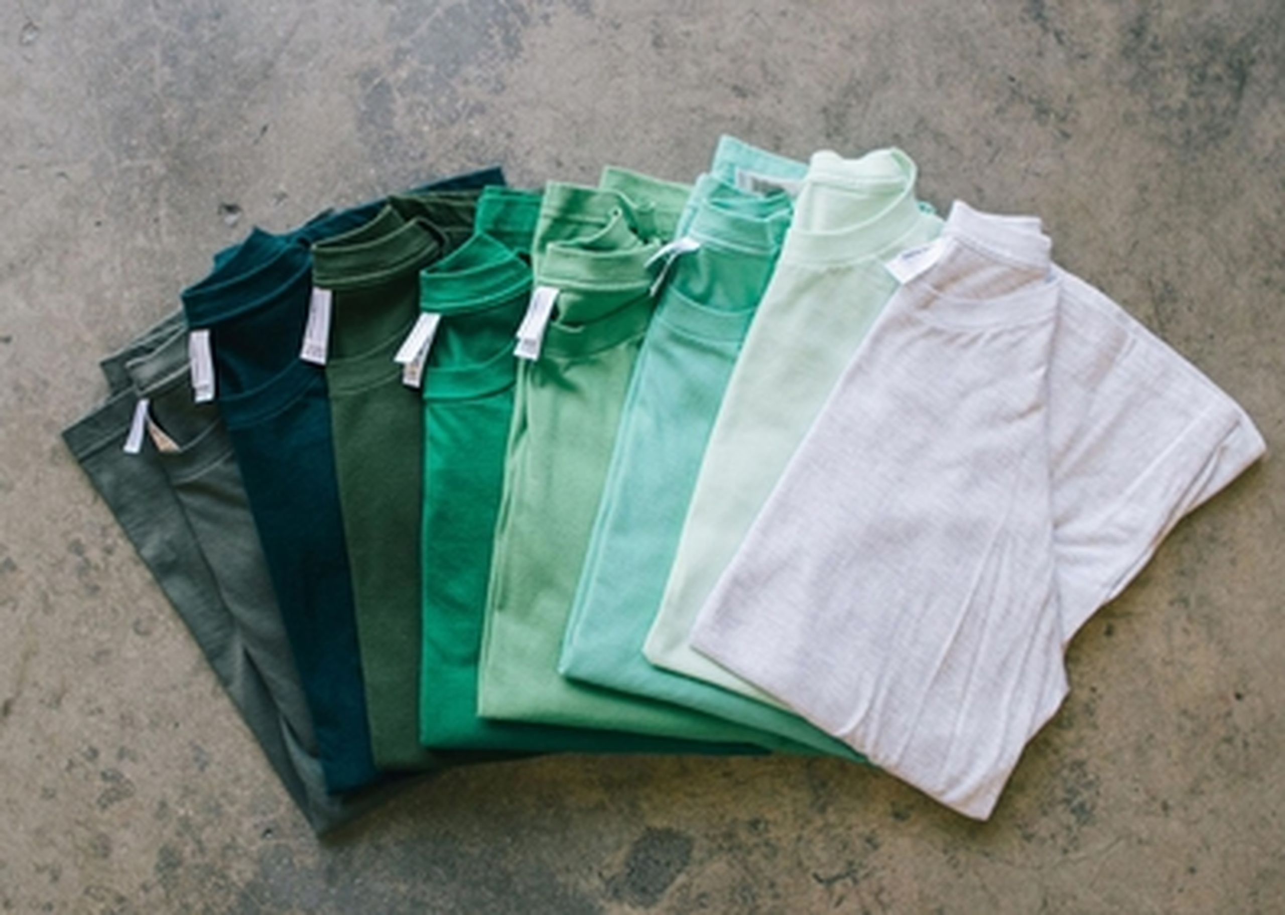 a collection of green shirts from white to dark green