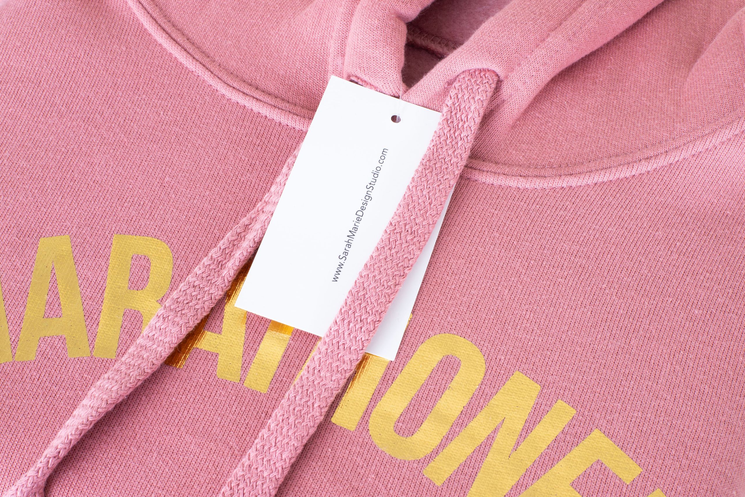 A custom hang tag on a pink sweatshirt with foil ink