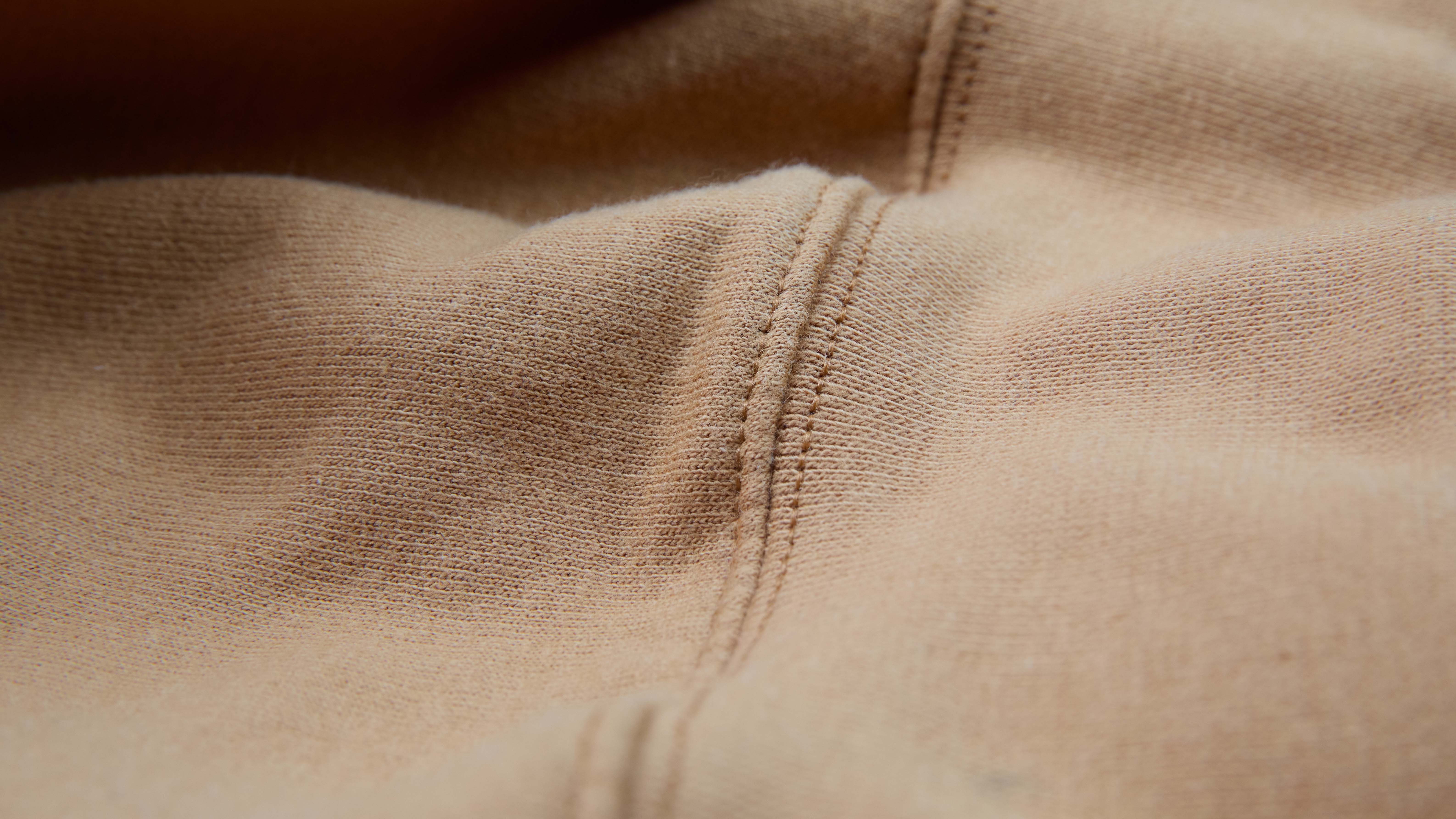 close up on a hoodies seam that is tan