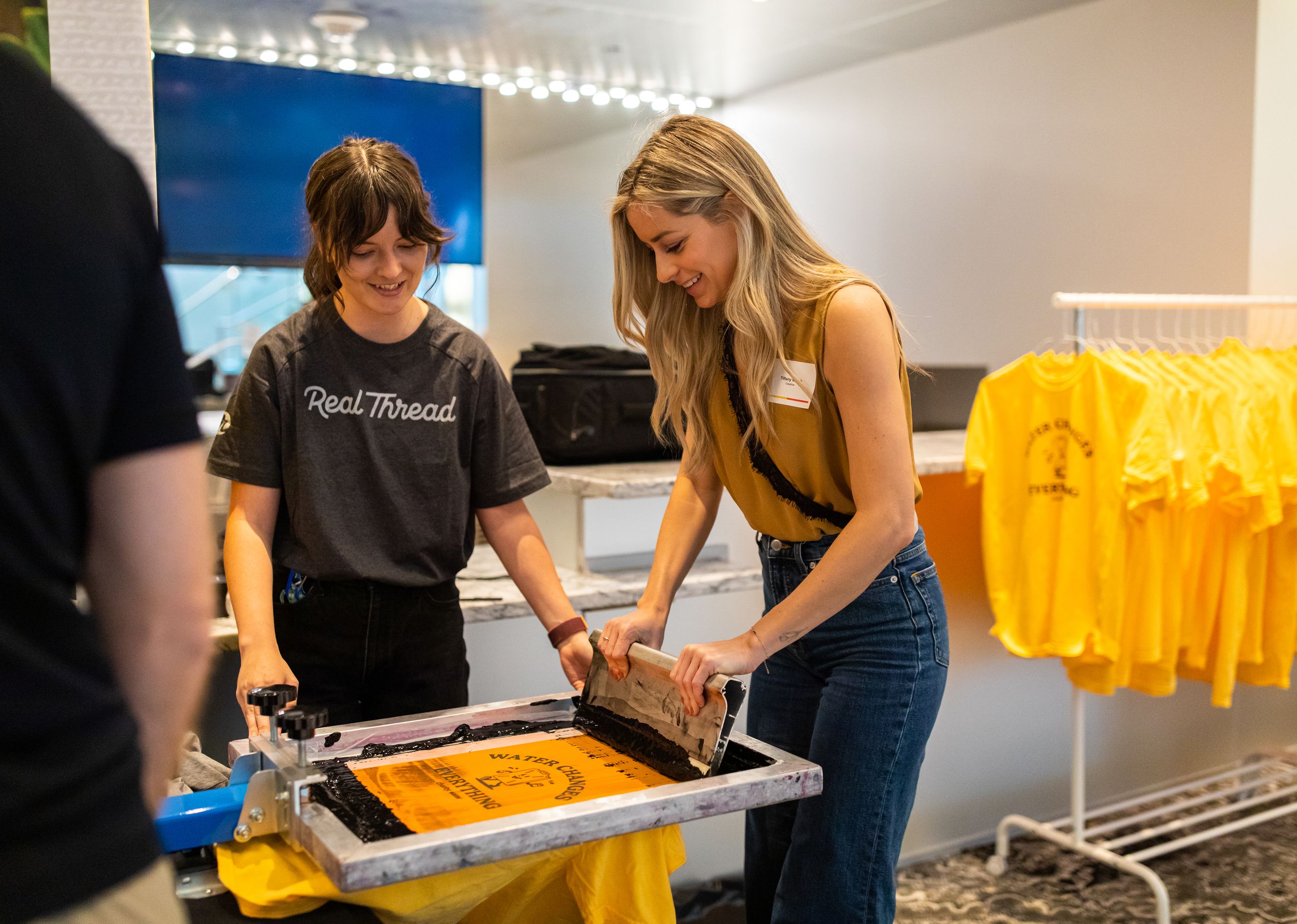 Two women live screen-printing at an event