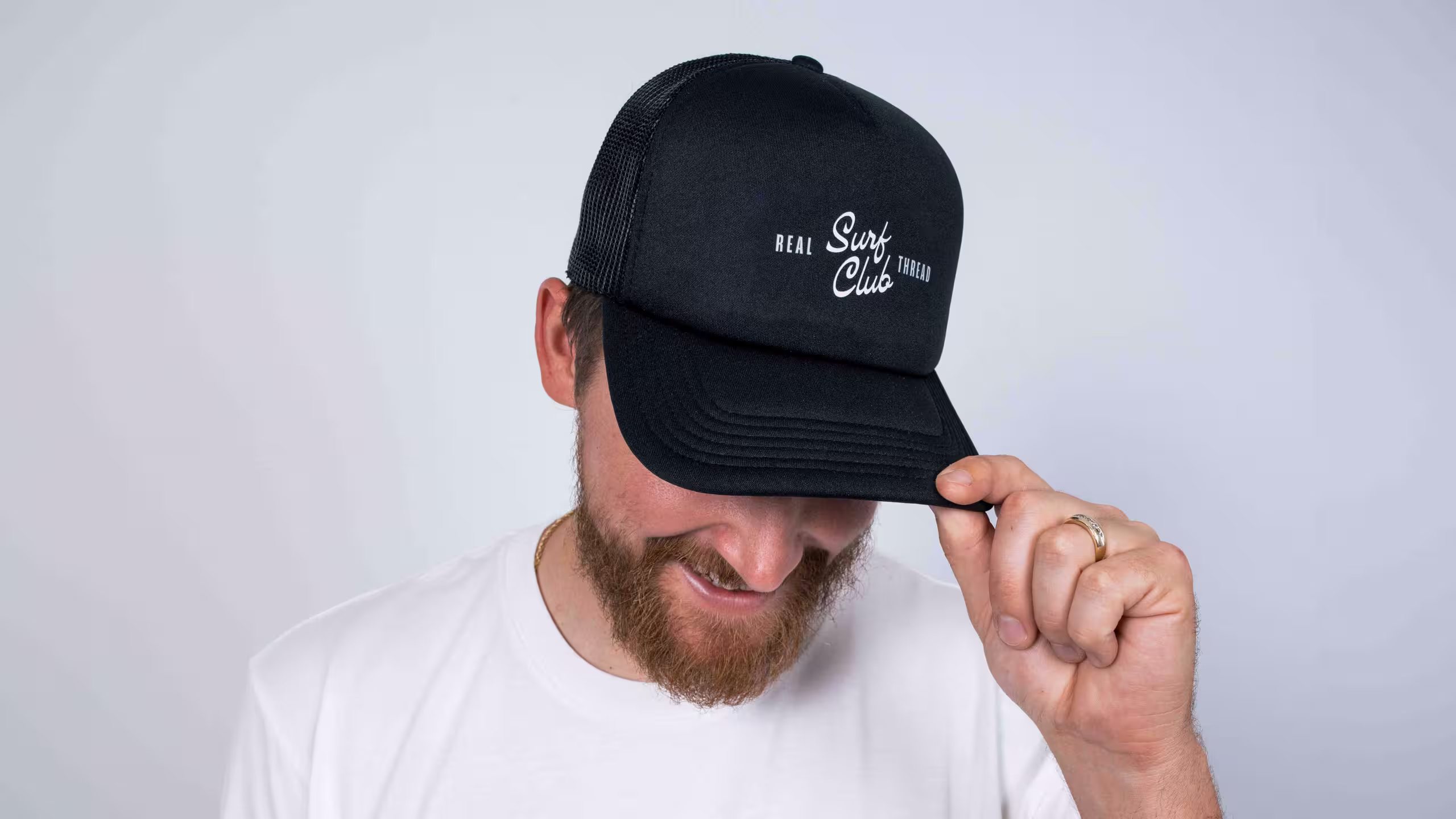 man wearing a black hat with surf club printed on it