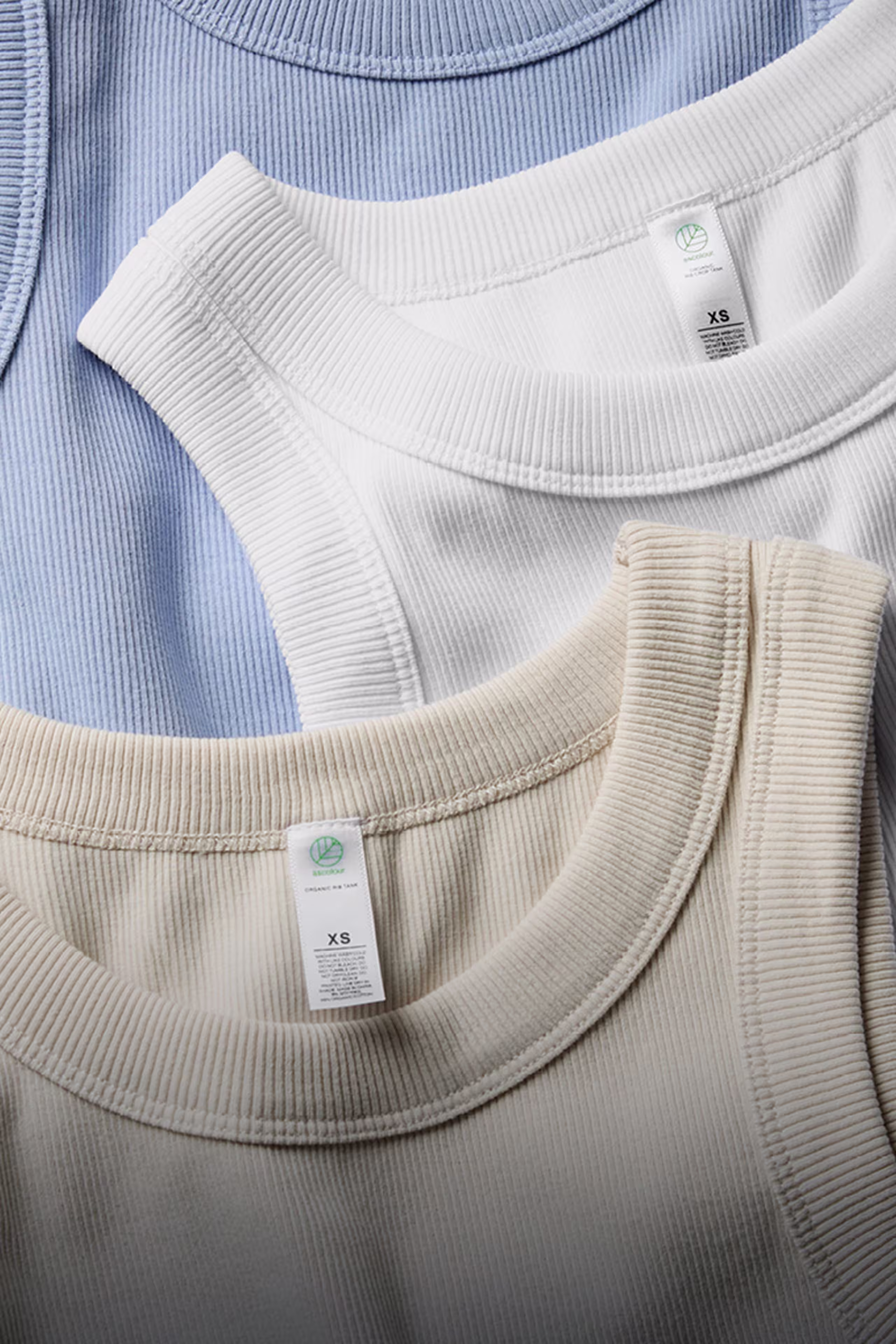 three tank tops laying flat on top of each other