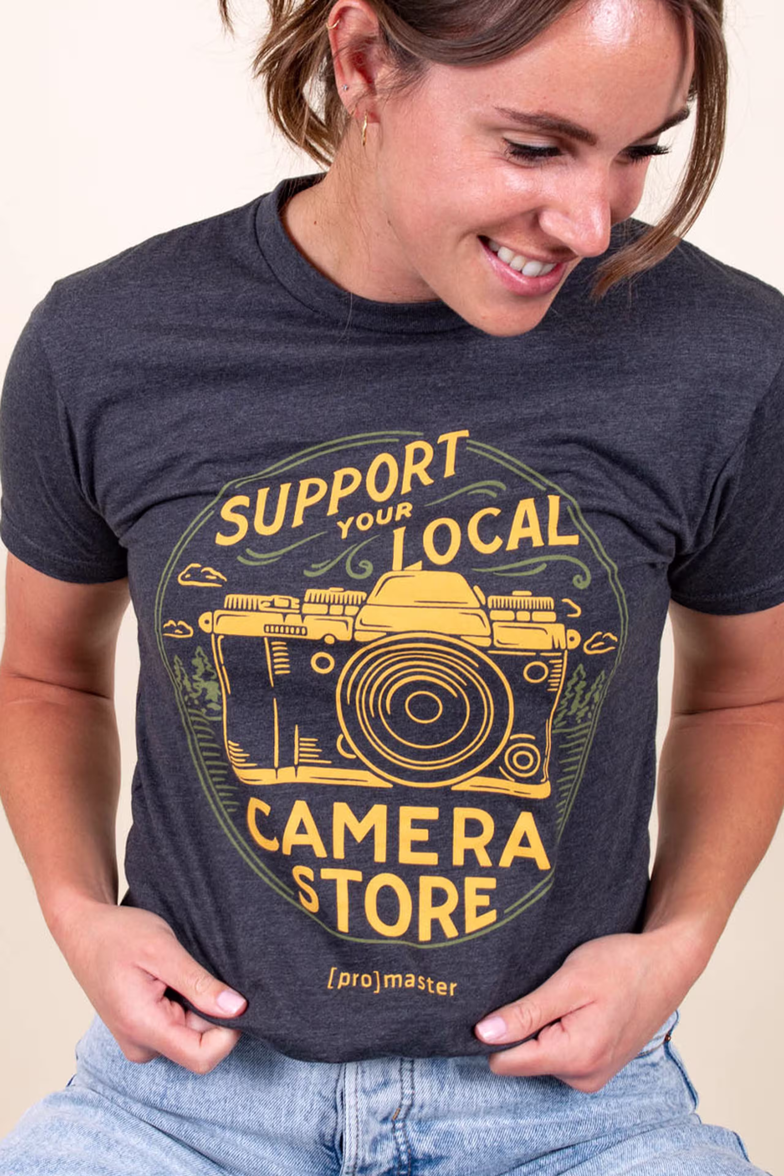 women wearing a navy tri-blend t-shirt with a yellow camera illustration printed on the front