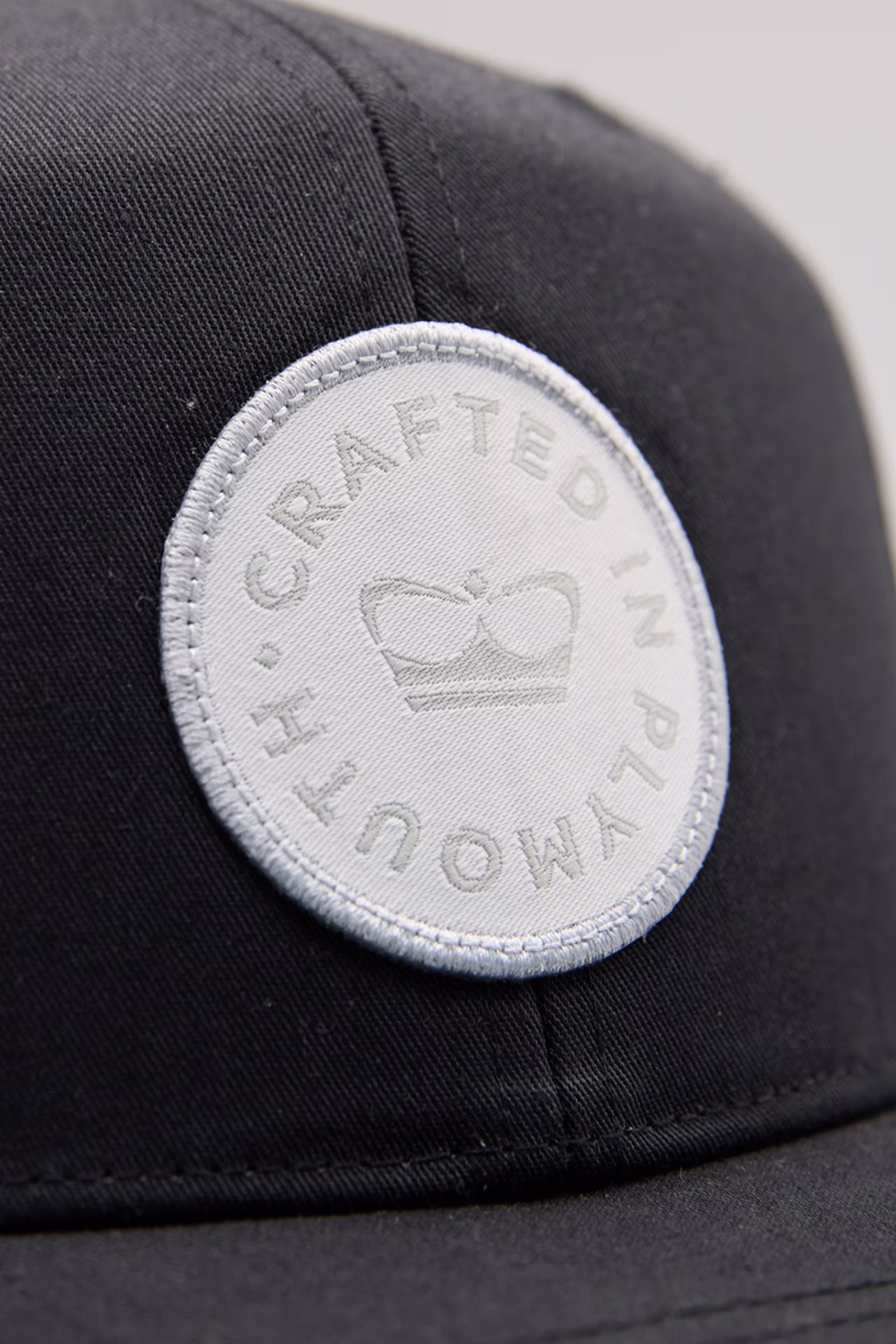 a white woven circle patch on a black hat