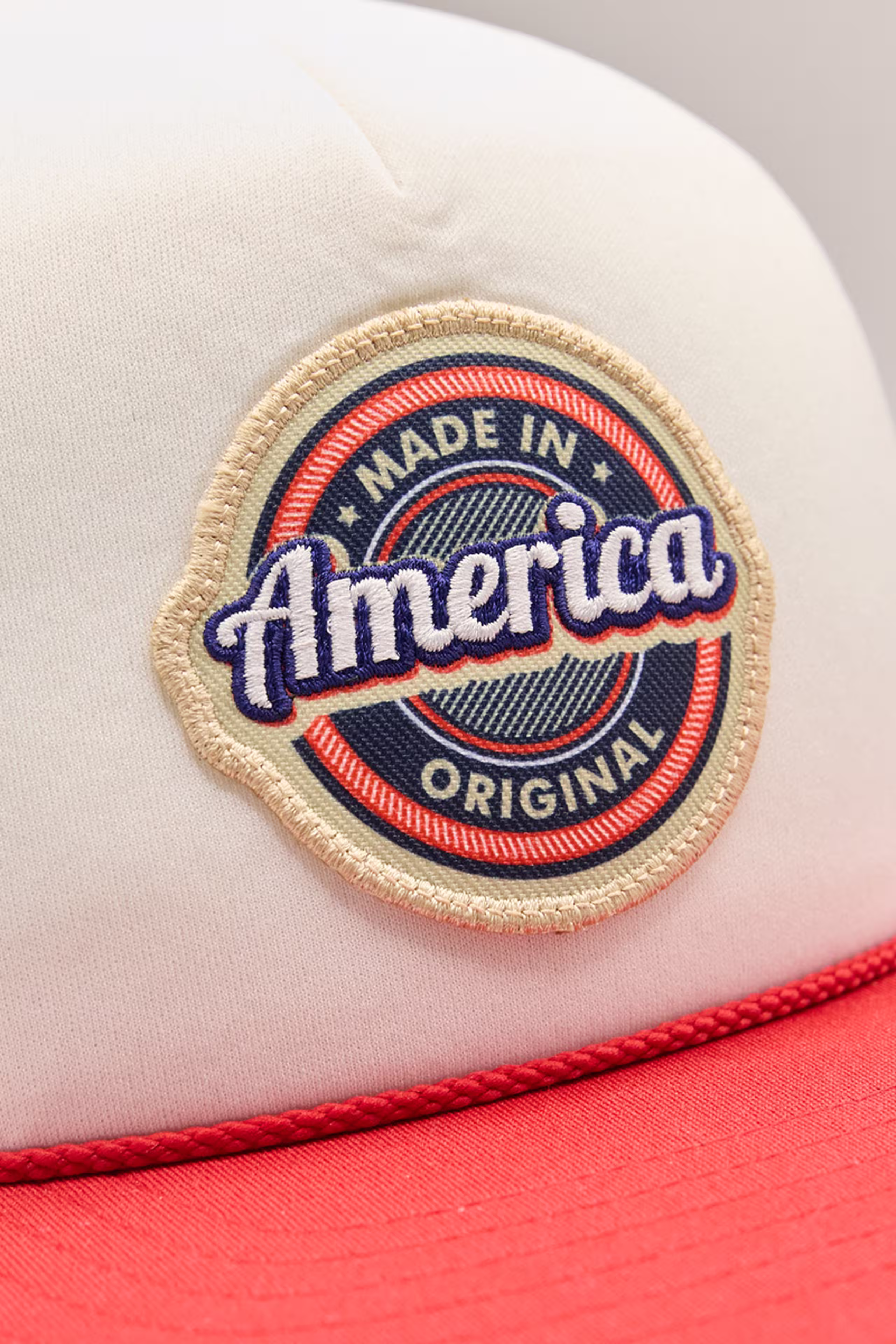 a red, white, blue, and tan circle print stitch patch with the word America