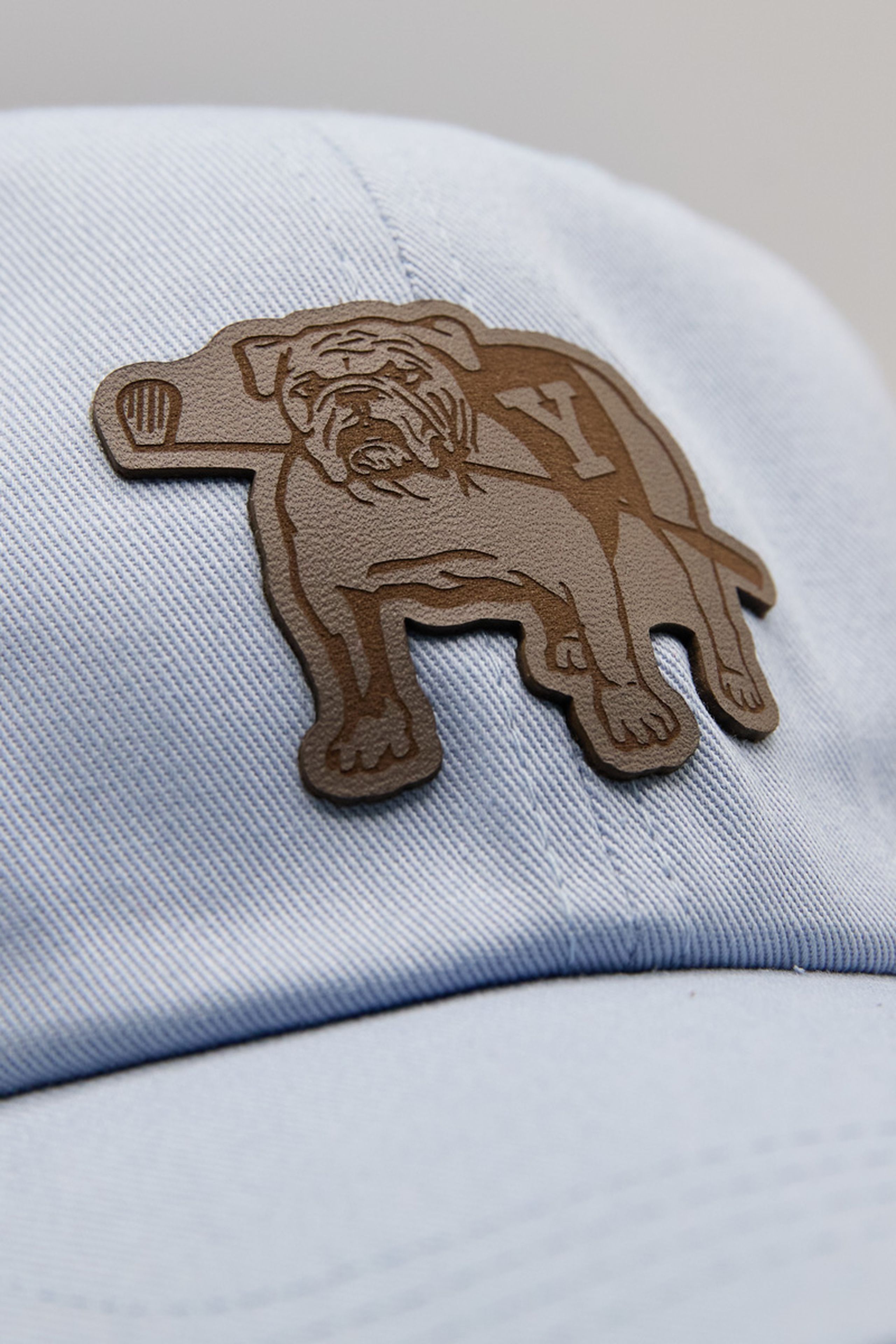 a leather patch of a dog and a golf club on a blue hat