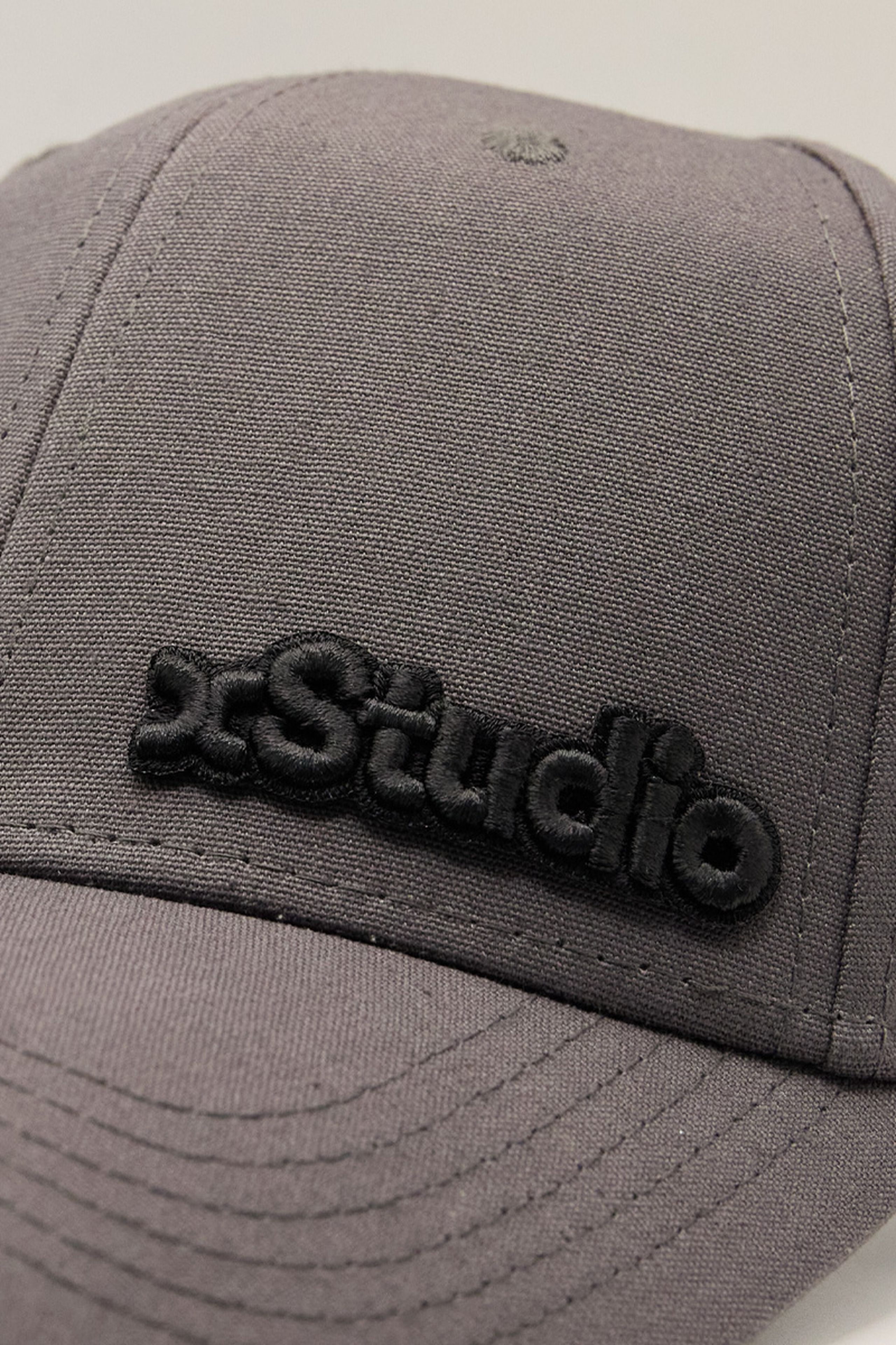 close-up of a black 3d embroidery patch on a grey hat