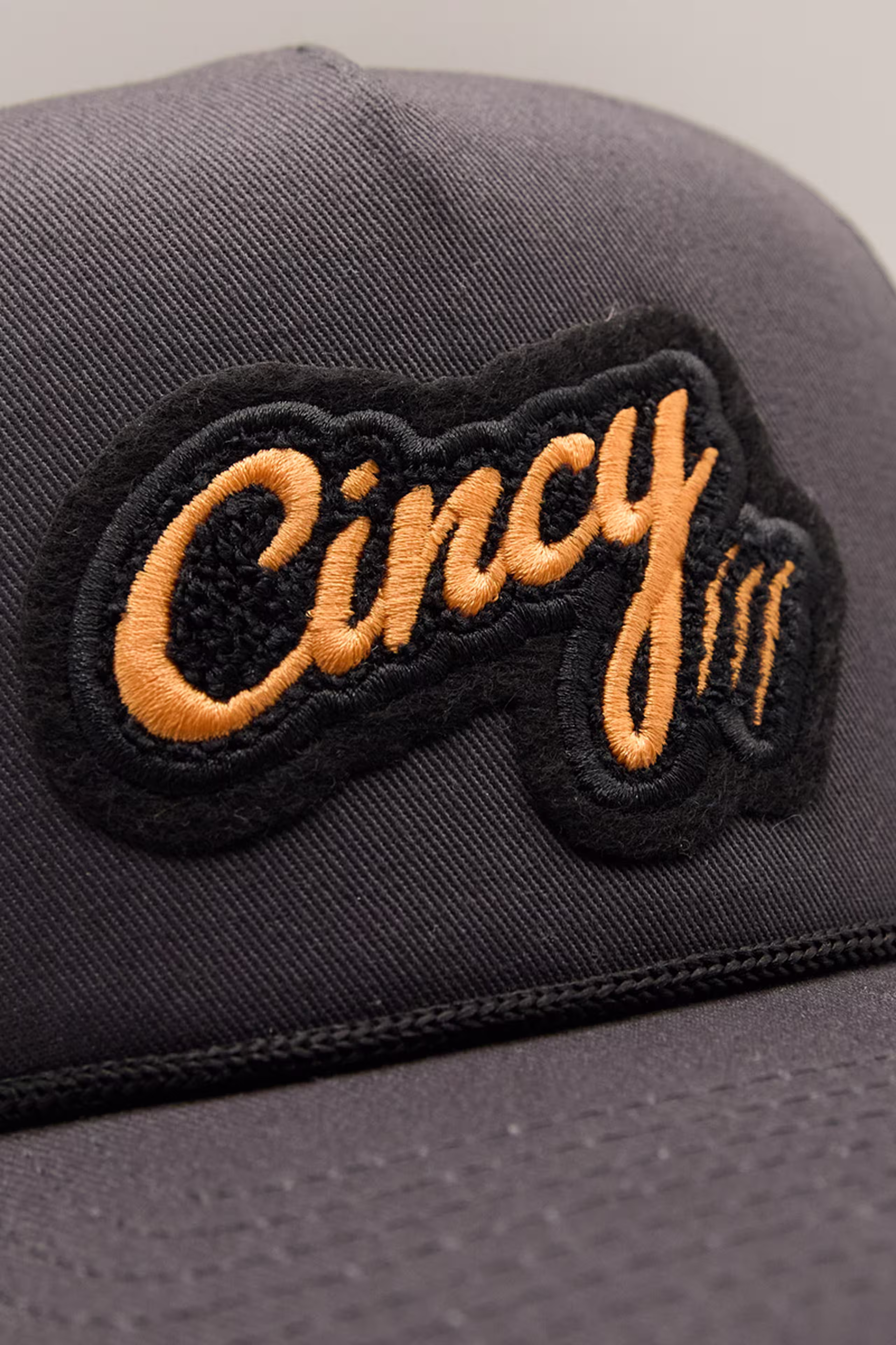 an orange and black chenille patch with the word cincy