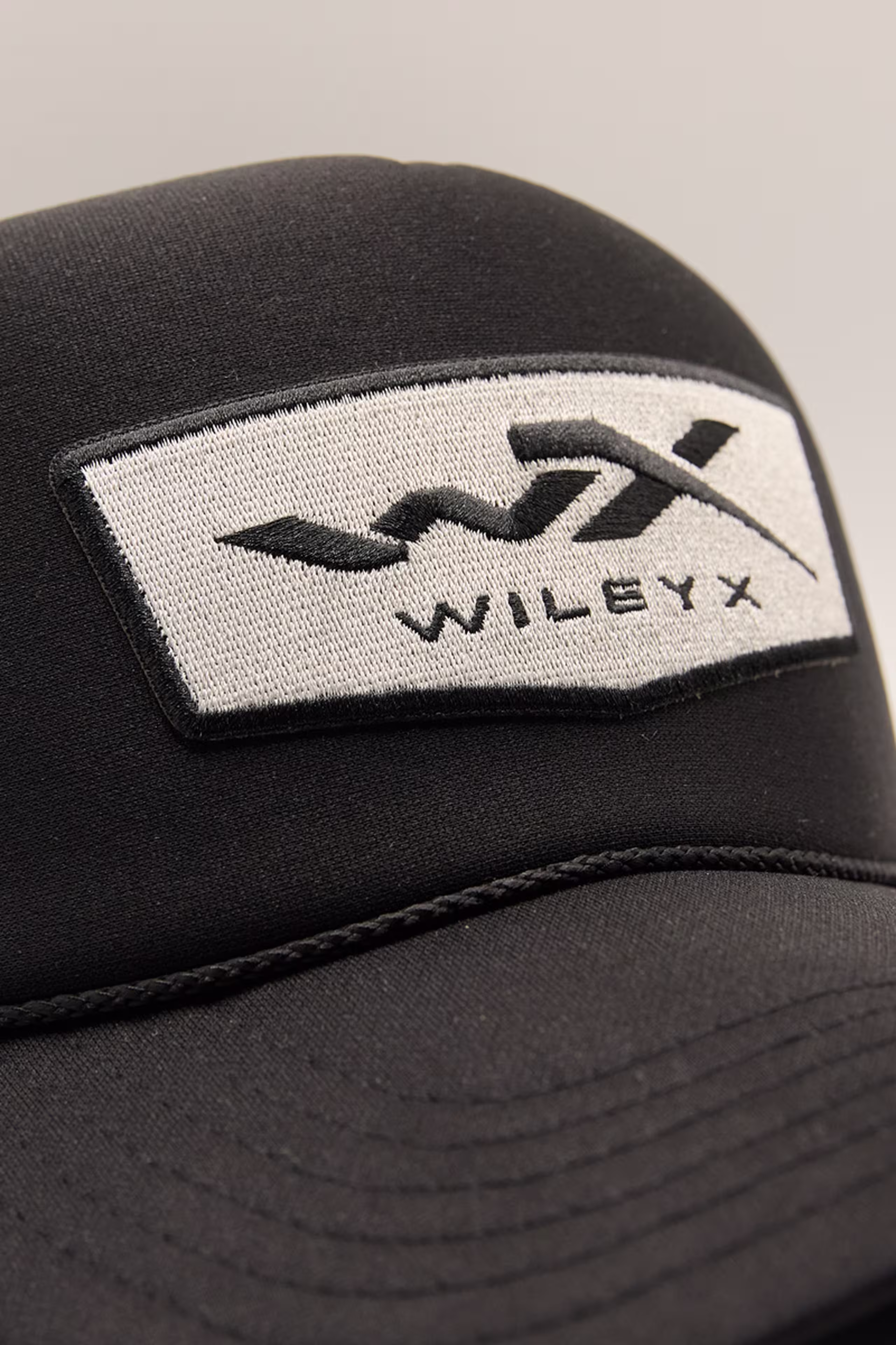 black and silver embroidered patch with the letters w x and words wileyx