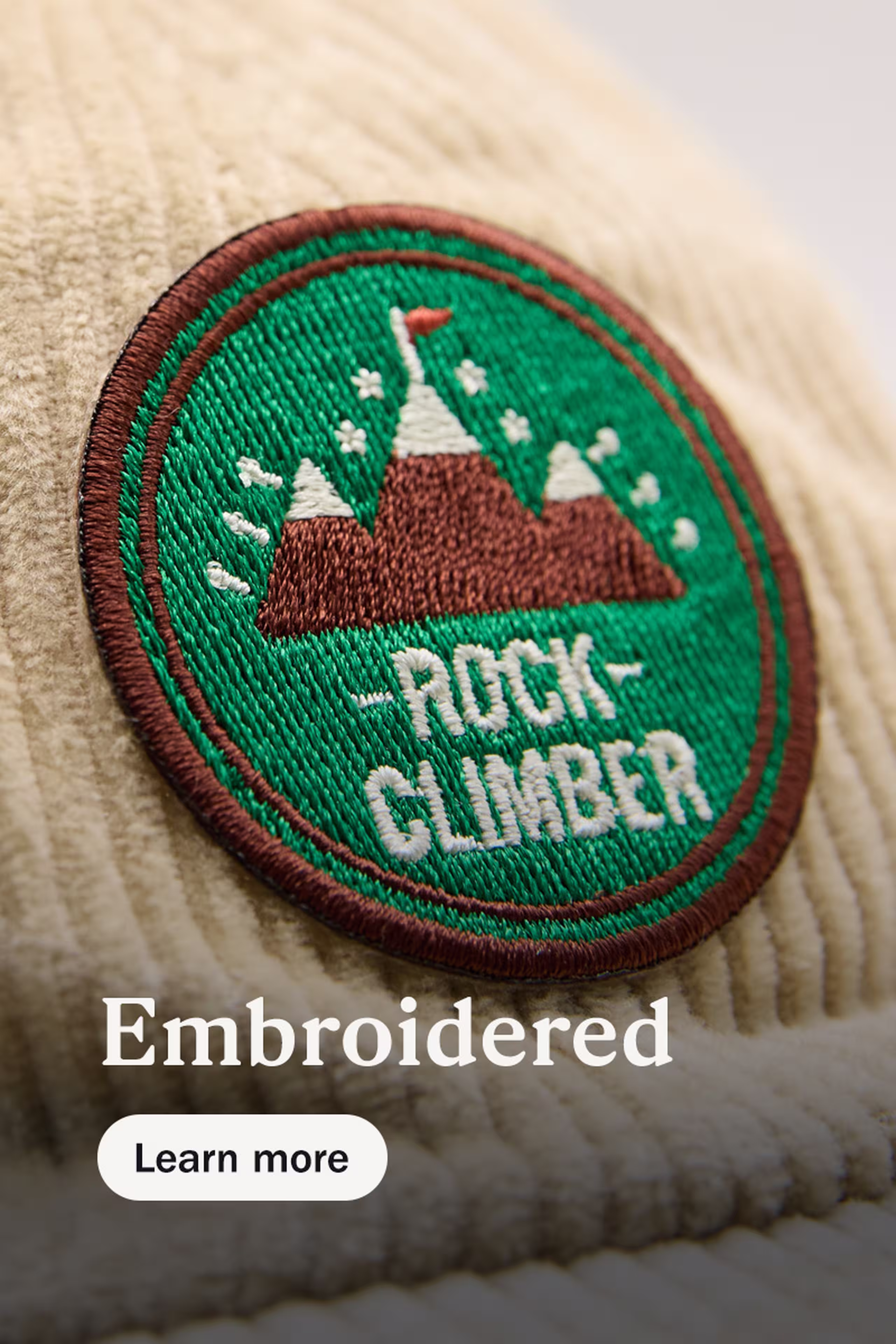 embroidered - learn more - circle embroidery logo of mountains and the words rock climber