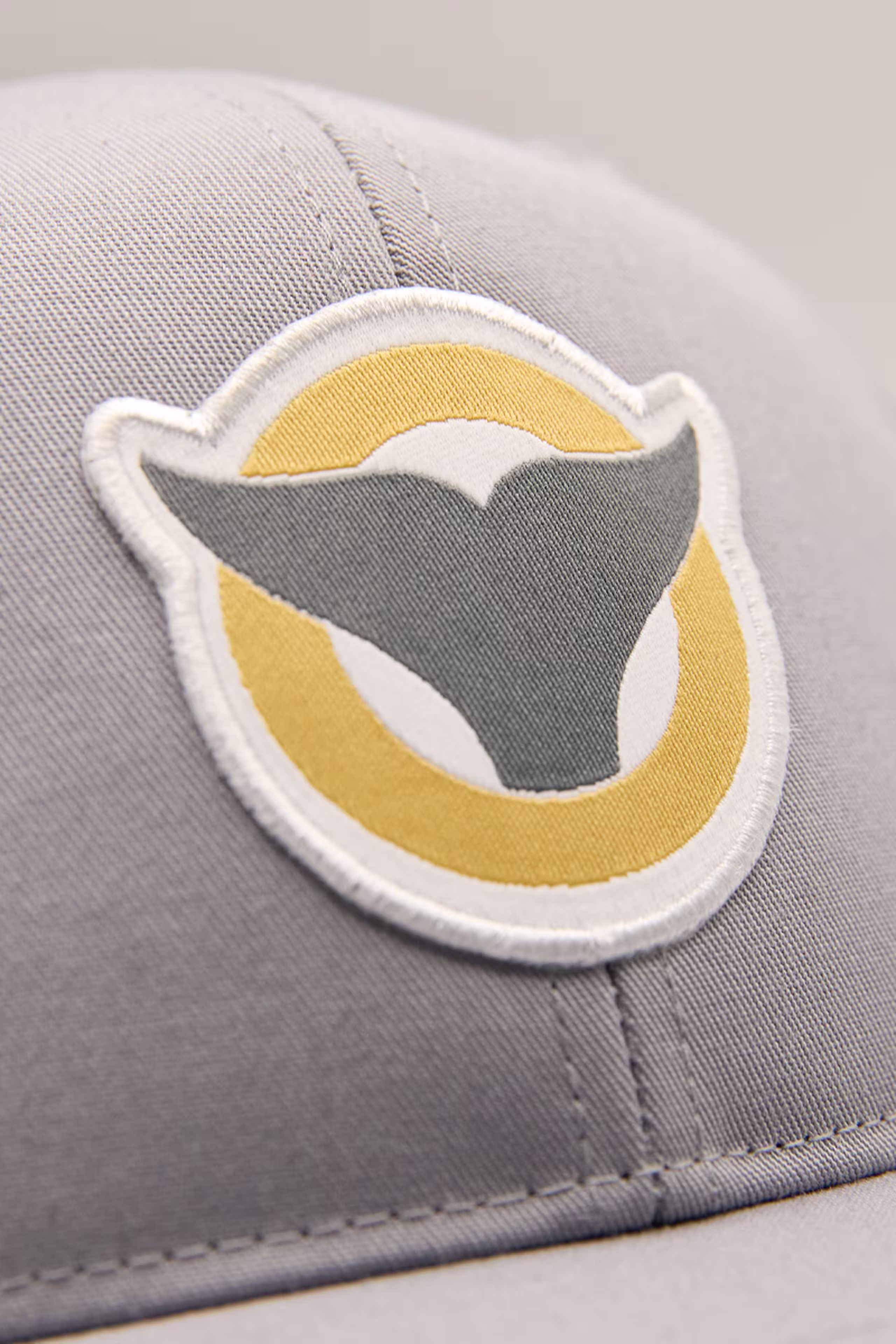close up of a dolphin fin and circle illustration as a woven patch