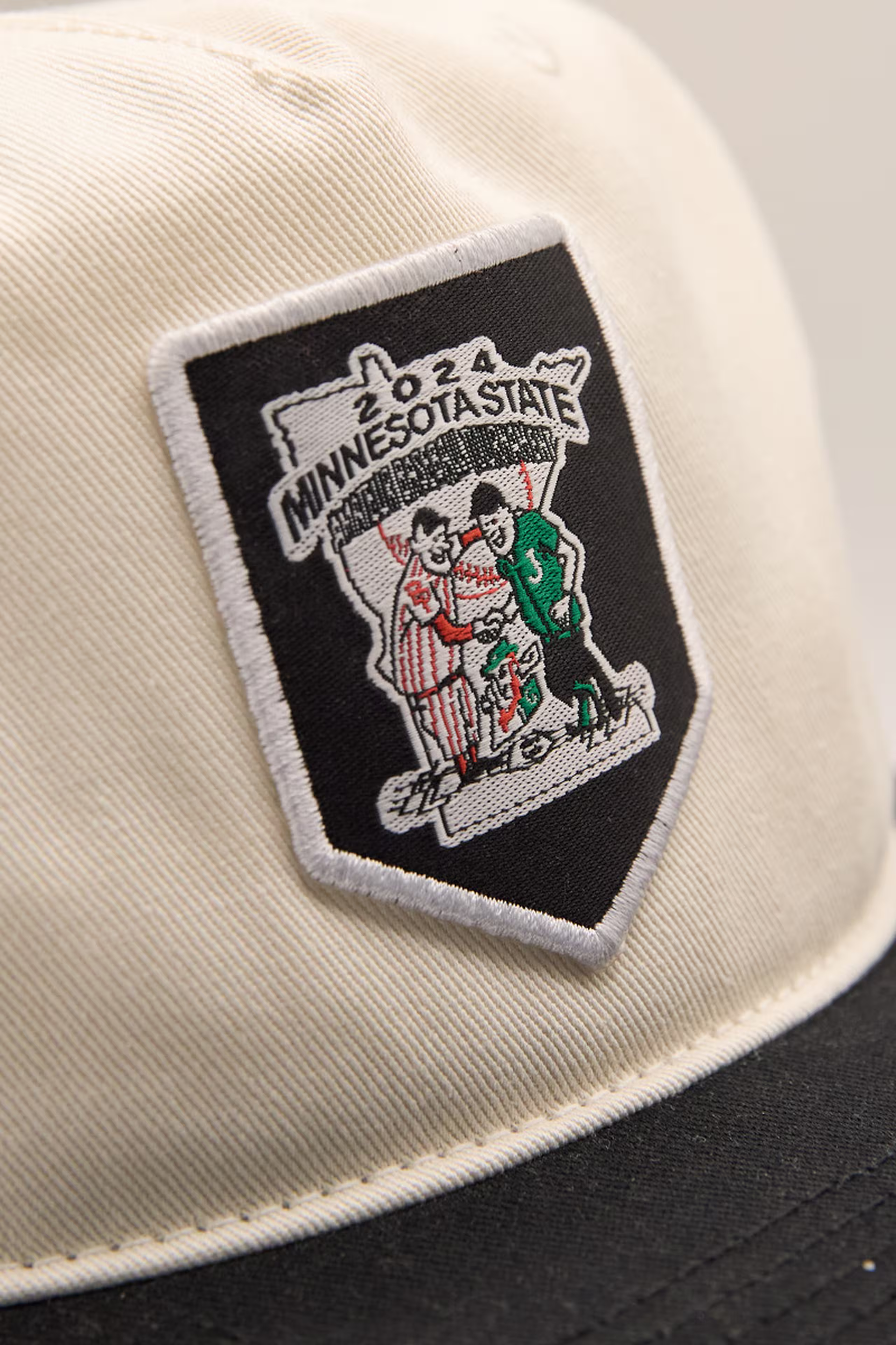 close up of a black woven patch with baseball theming and Minnesota
