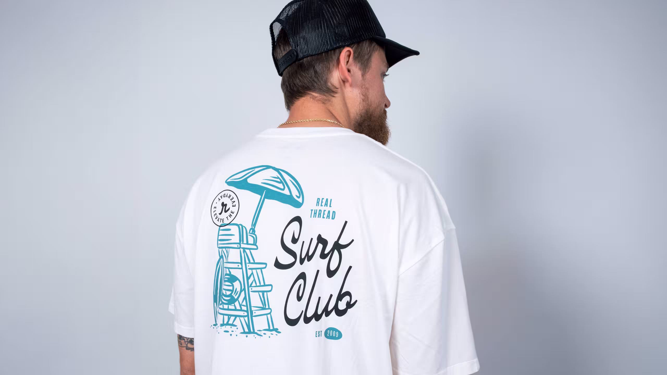 man wearing a white shirt with the words Surf Club