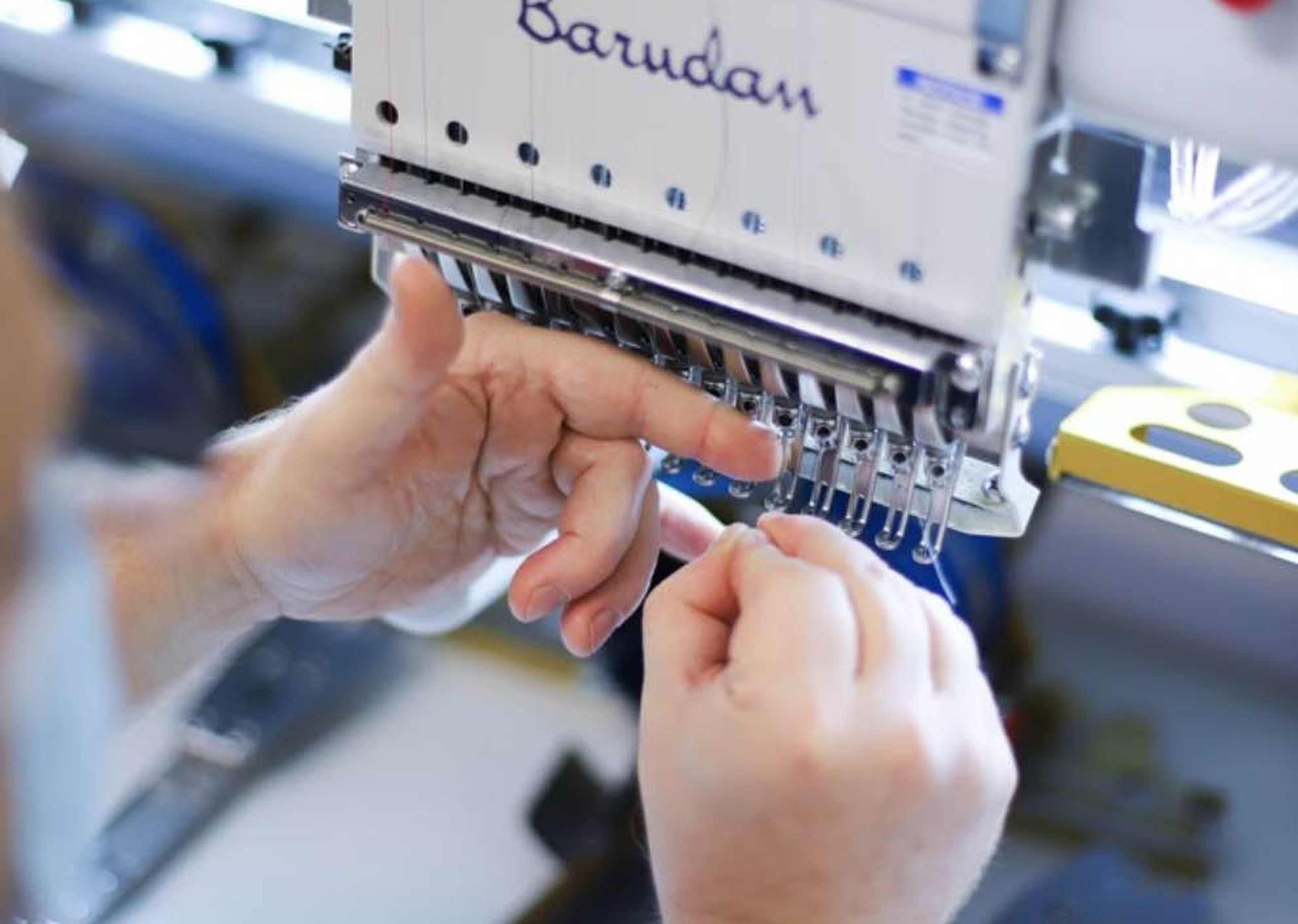 close up of someone prepping the embroidery machine
