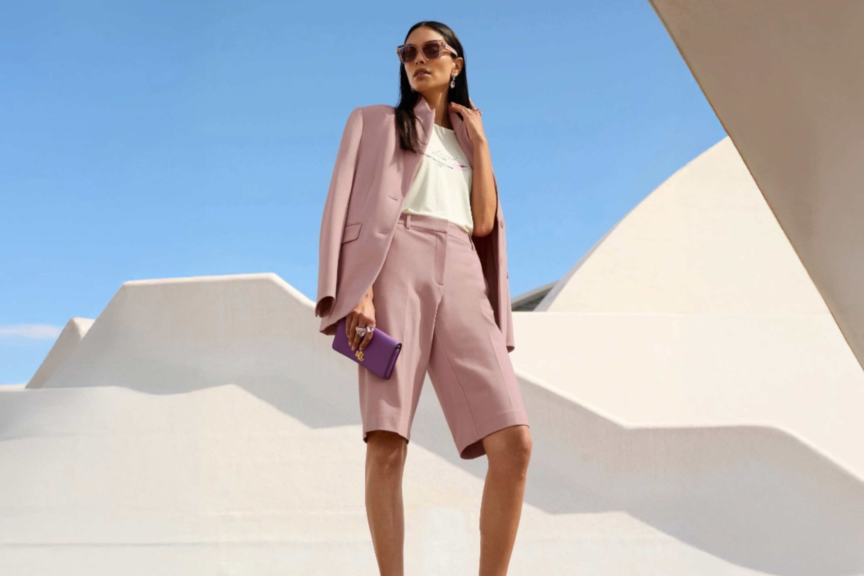 Roséfarbener Bermuda-Anzug mit tailliertem Blazer und knieumspielender Shorts, ein moderner Sommerlook für Hochzeitsgäste.