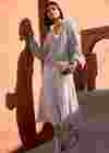 Frau mit fliederfarbenem Plisseerock, Strickjacke und Bluse