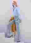 Fashionable style for women with jeans, blue striped blouse with rhinestones and beige coat.