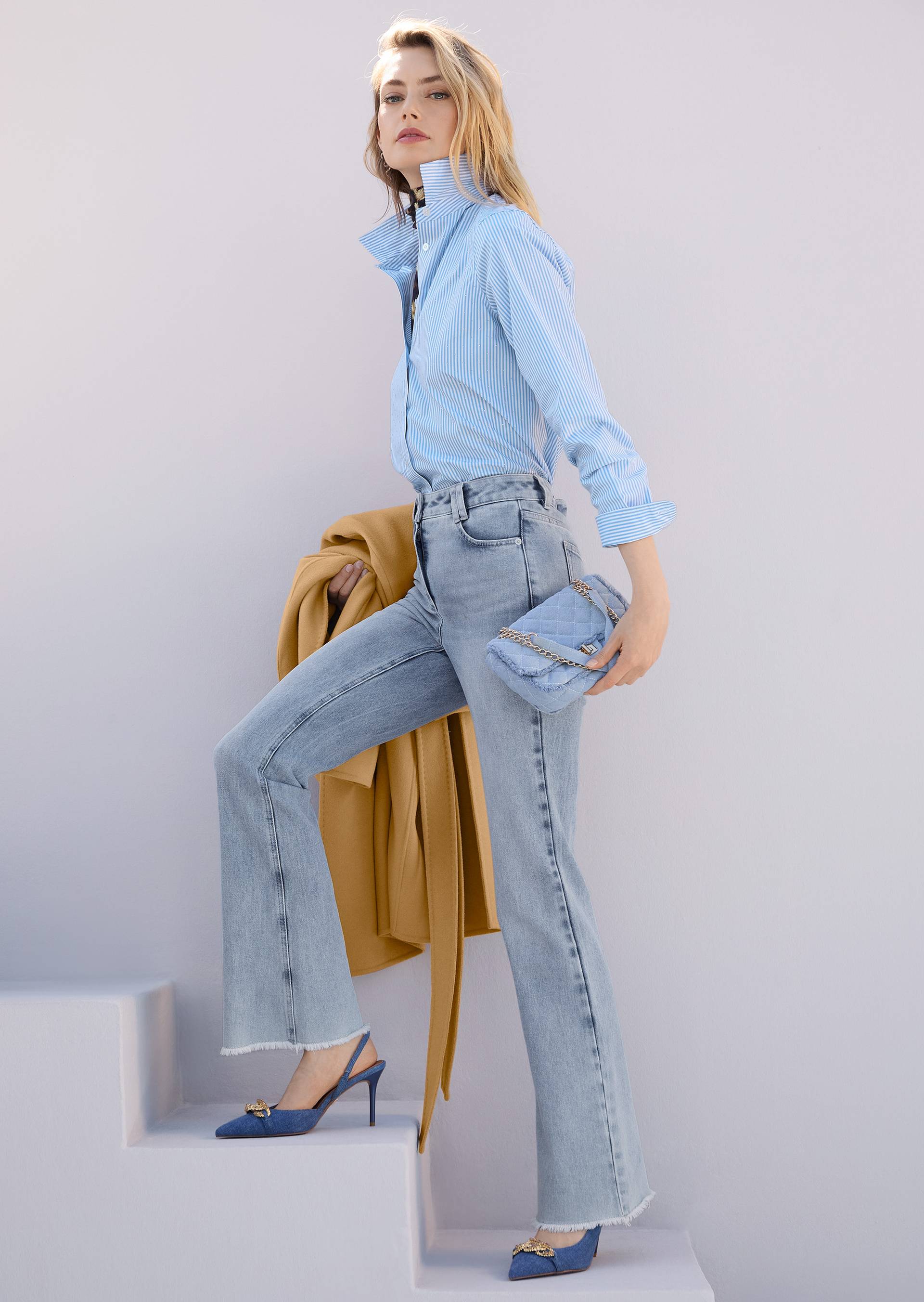 Fashionable style for women with jeans, blue striped blouse with rhinestones and beige coat.