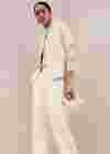 Overgangslook voor de herfst met witte cape-achtige vest, blouse en flanellen broek