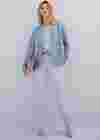 Frau im pastelligen Herbstlook mit hellblauem Blazer, mintfarbenem Pullover und fliederfarbener Hose.