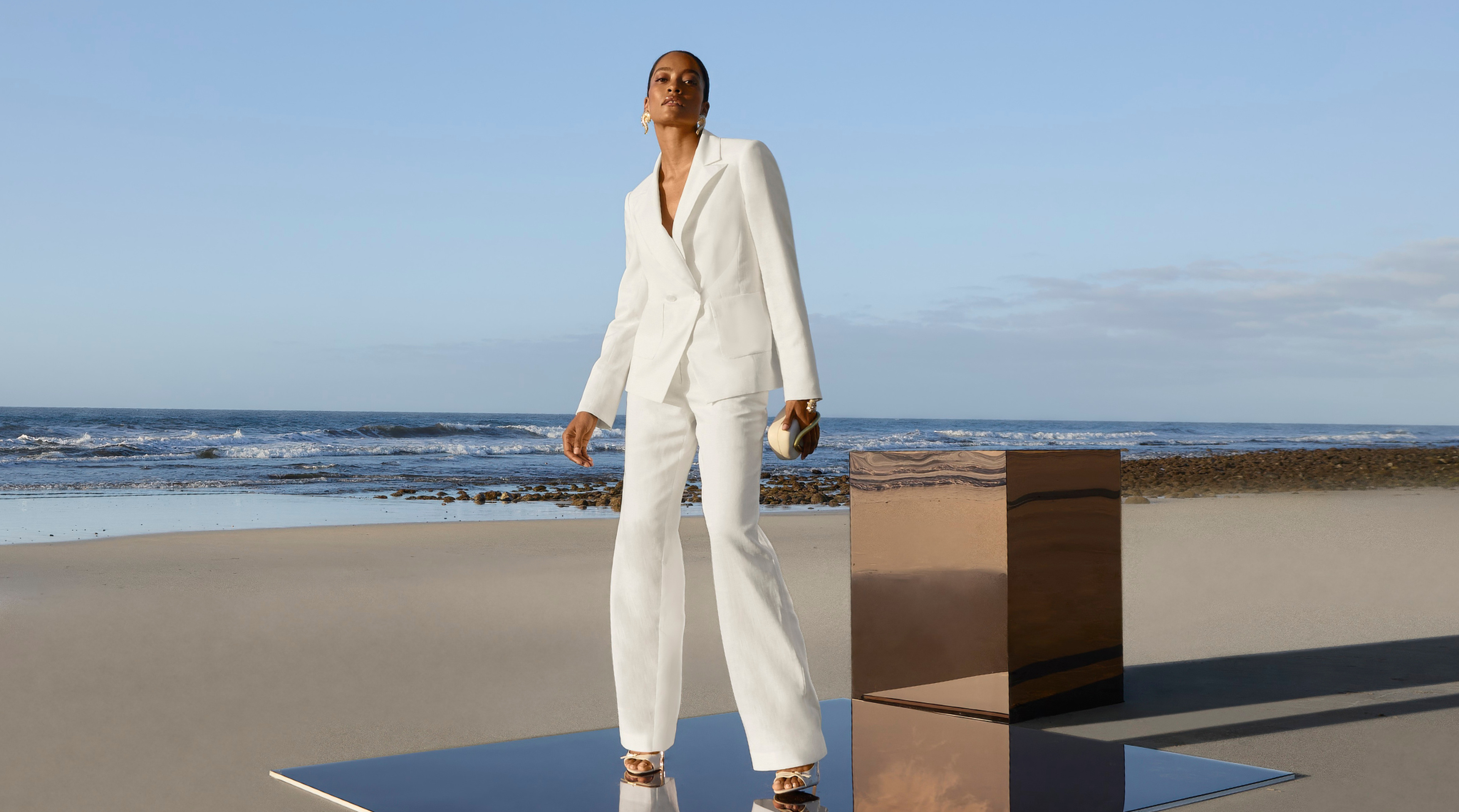 Eine Frau trägt einen elganten Hosenanzug in der Pantone® Trendfarbe Cloud Dancer. 