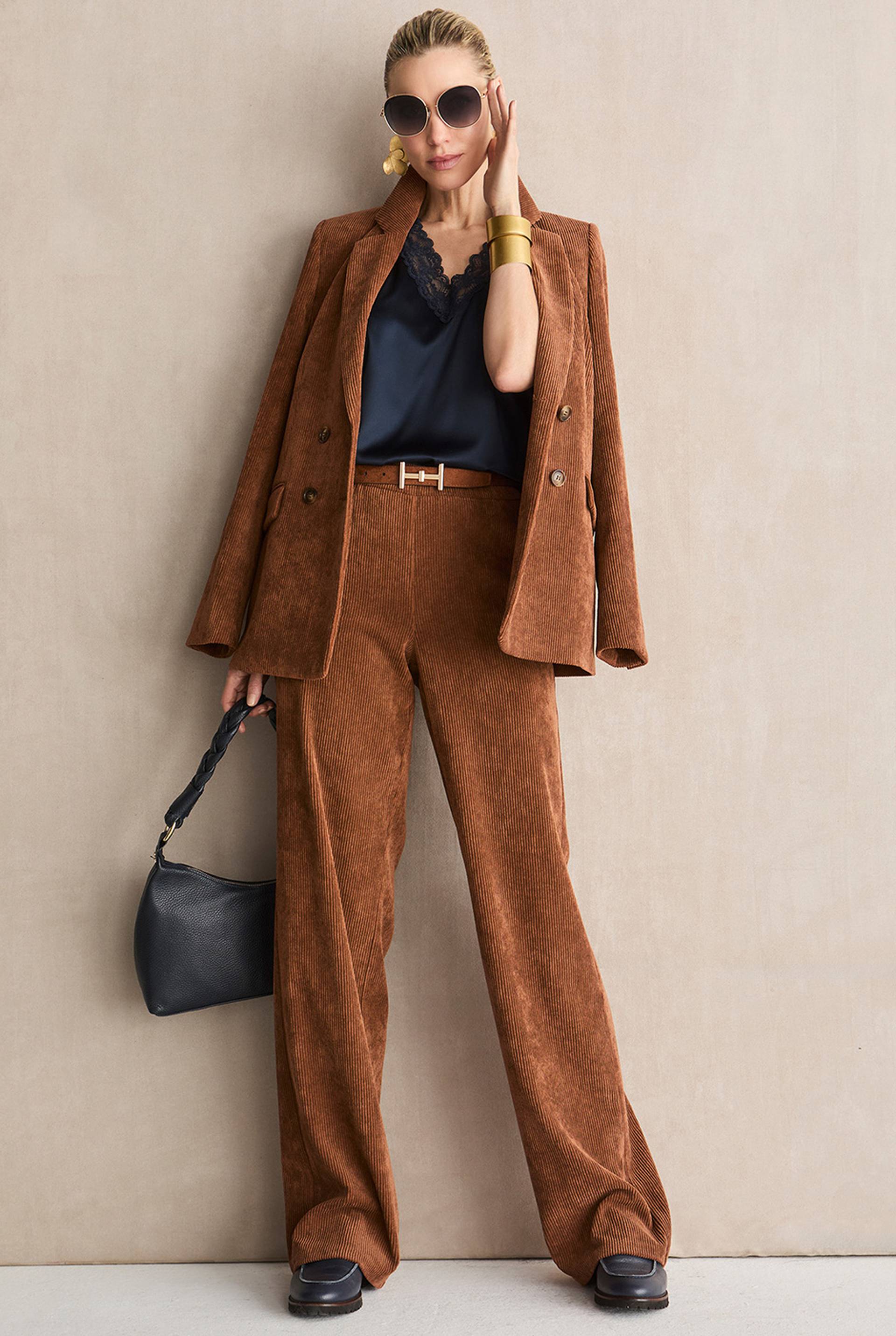 Brauner Cordanzug mit zweireihigem Blazer, weitem Hosenbein und dunklem Top mit Spitzenausschnitt