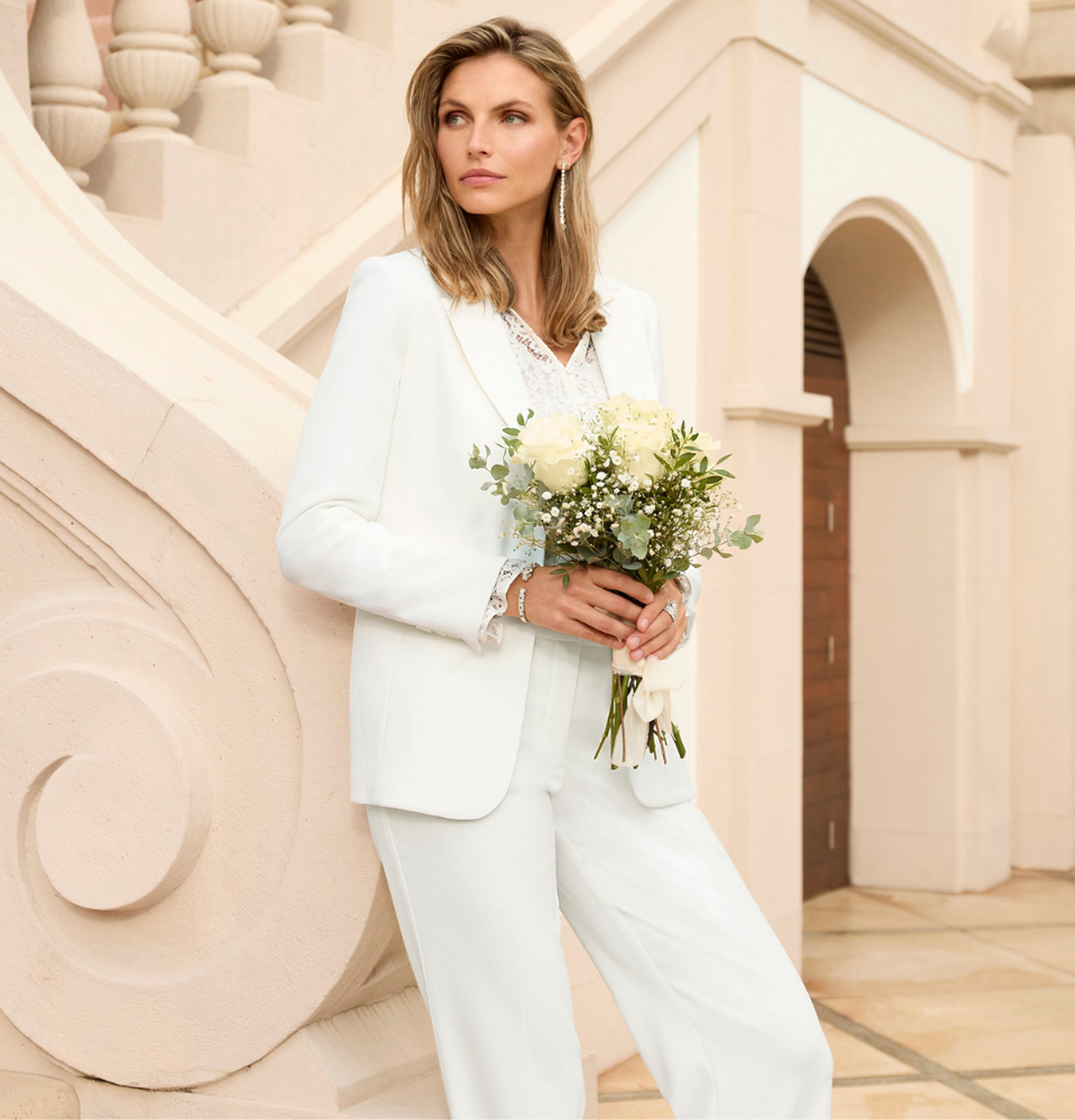 Dame in elegantem weißen Hosenanzug - perfektes Standesamt-Outfit als Braut