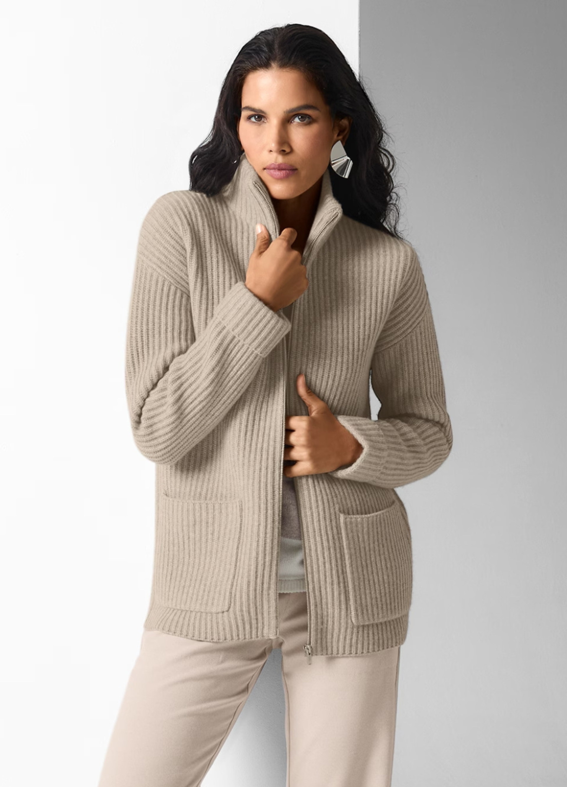 Die Frau trägt eine kuschelige Strickjacke.