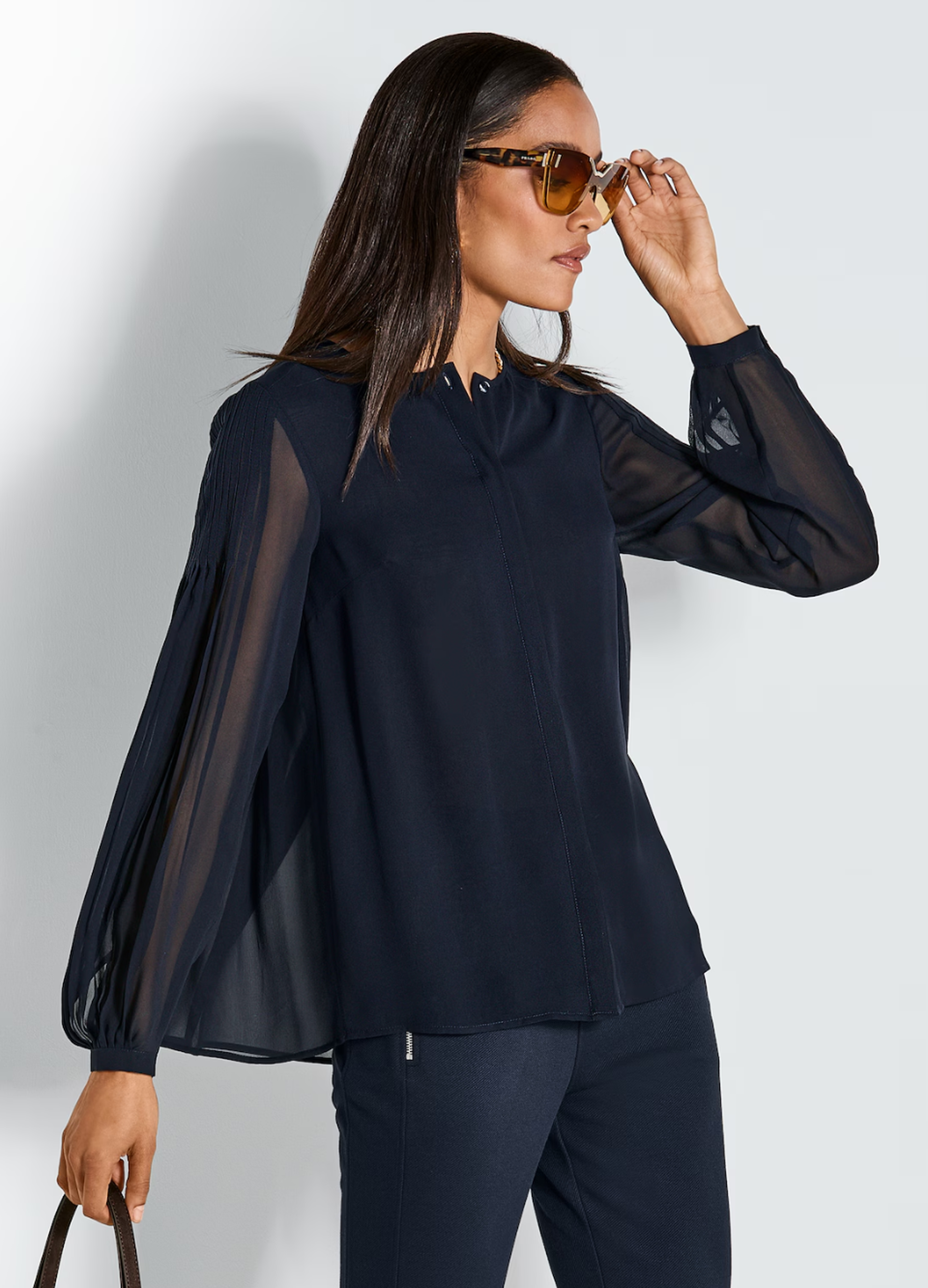 Dame mit dunkelblauer Plissee-Bluse