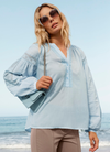 Hellblaue Bluse mit Ballonärmeln als lässiger Hemd-Trend 2026 am Meer