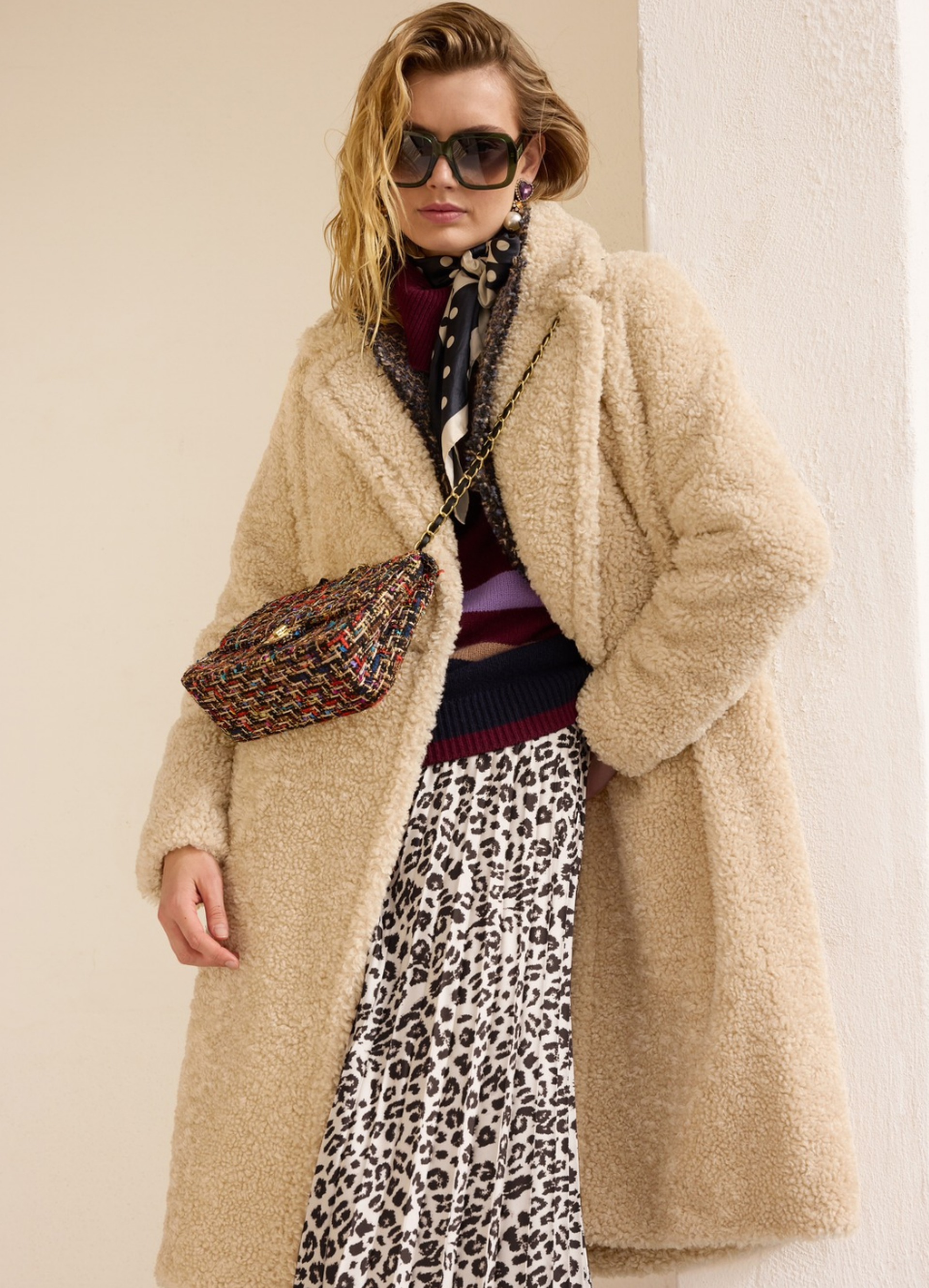Zwiebellook mit beigefarbenem Teddy-Mantel, gestreiftem Pullover und Leo-Rock für einen modernen Layering-Look