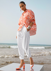 Orangefarbene Bluse als eleganter Beach-Look am Meer