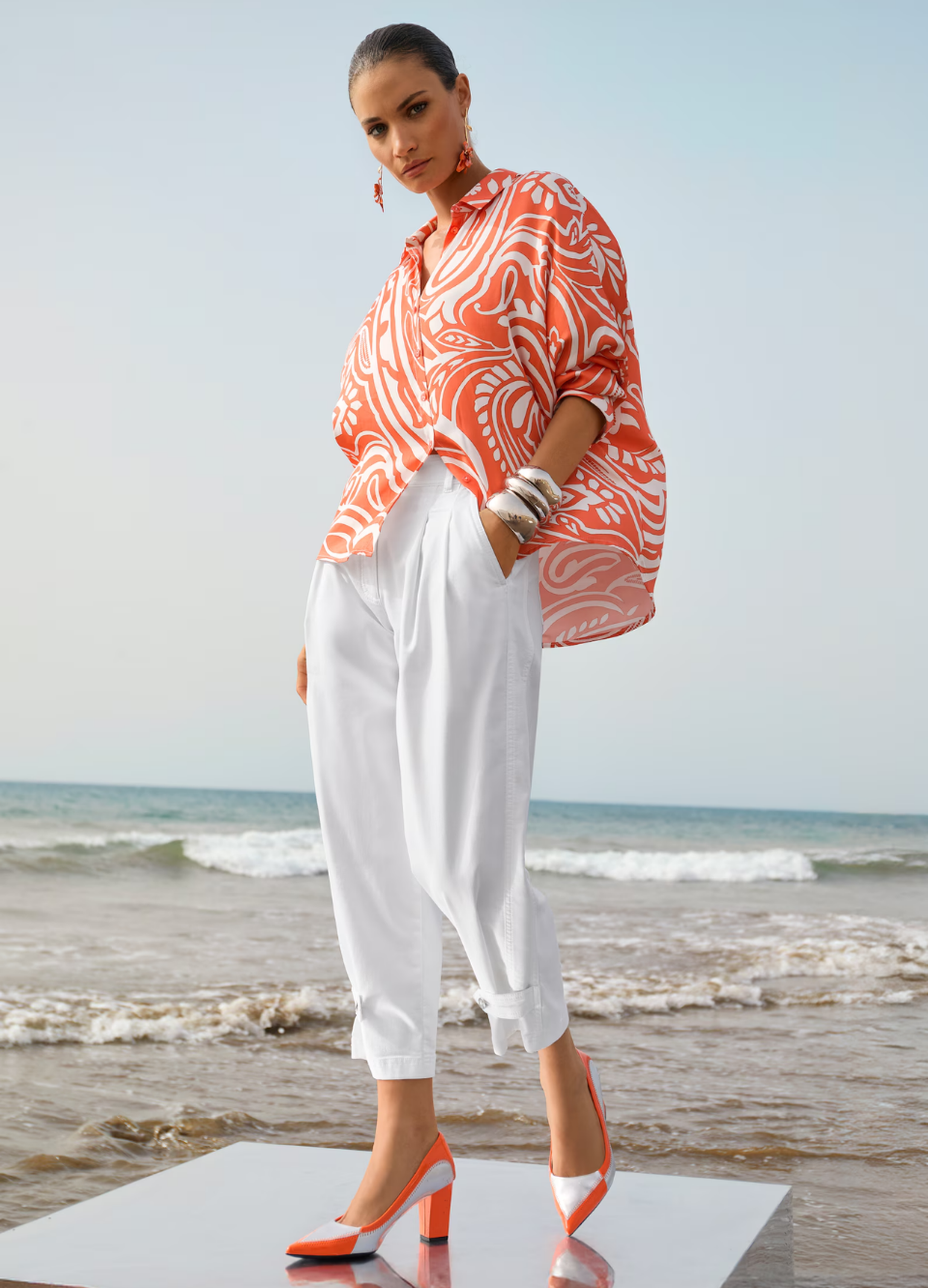 Orangefarbene Bluse als eleganter Beach-Look am Meer