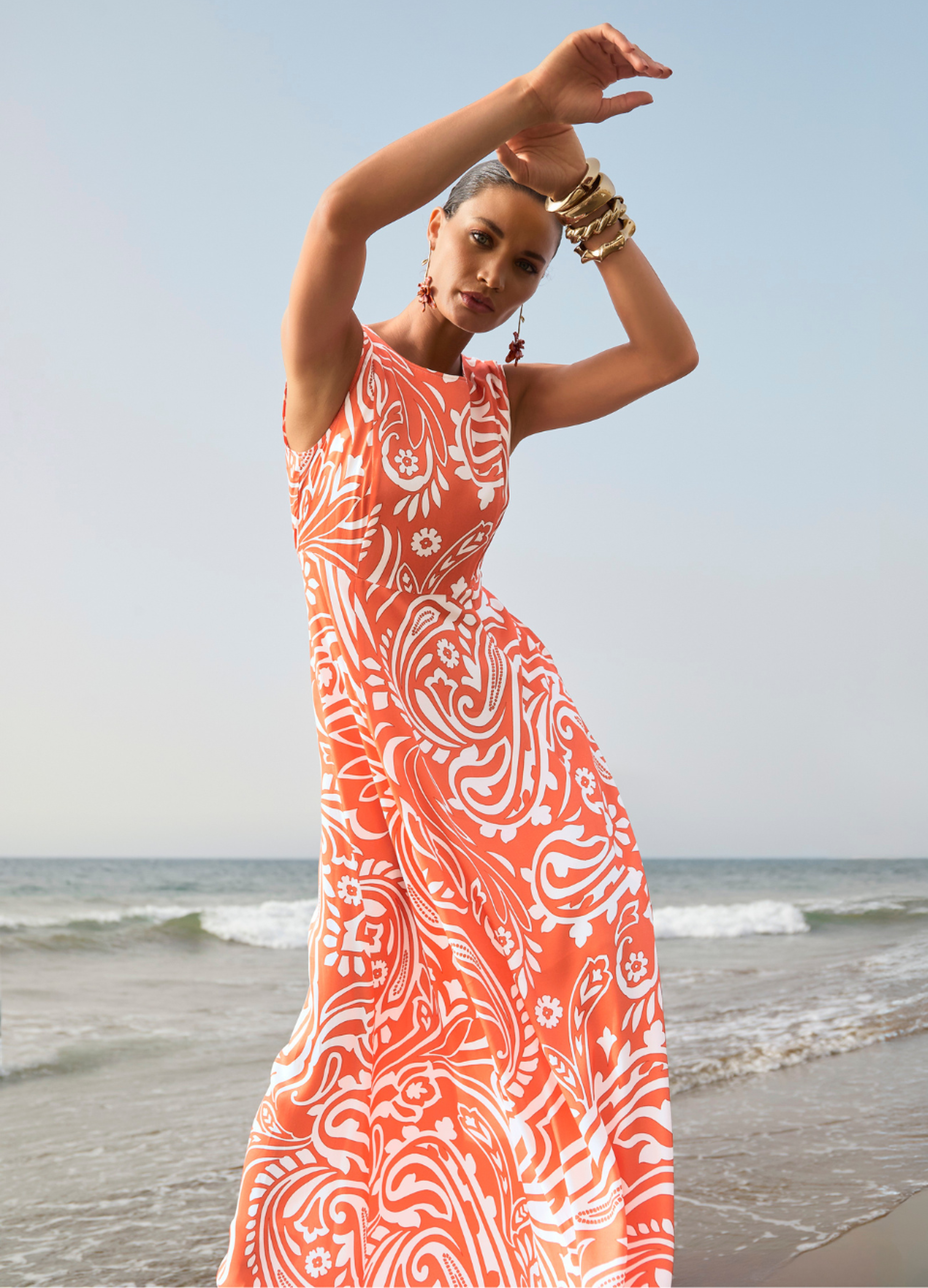 Langes Kleid mit grafischem Muster in Orange und Weiß, fließende Silhouette für einen eleganten Sommerlook