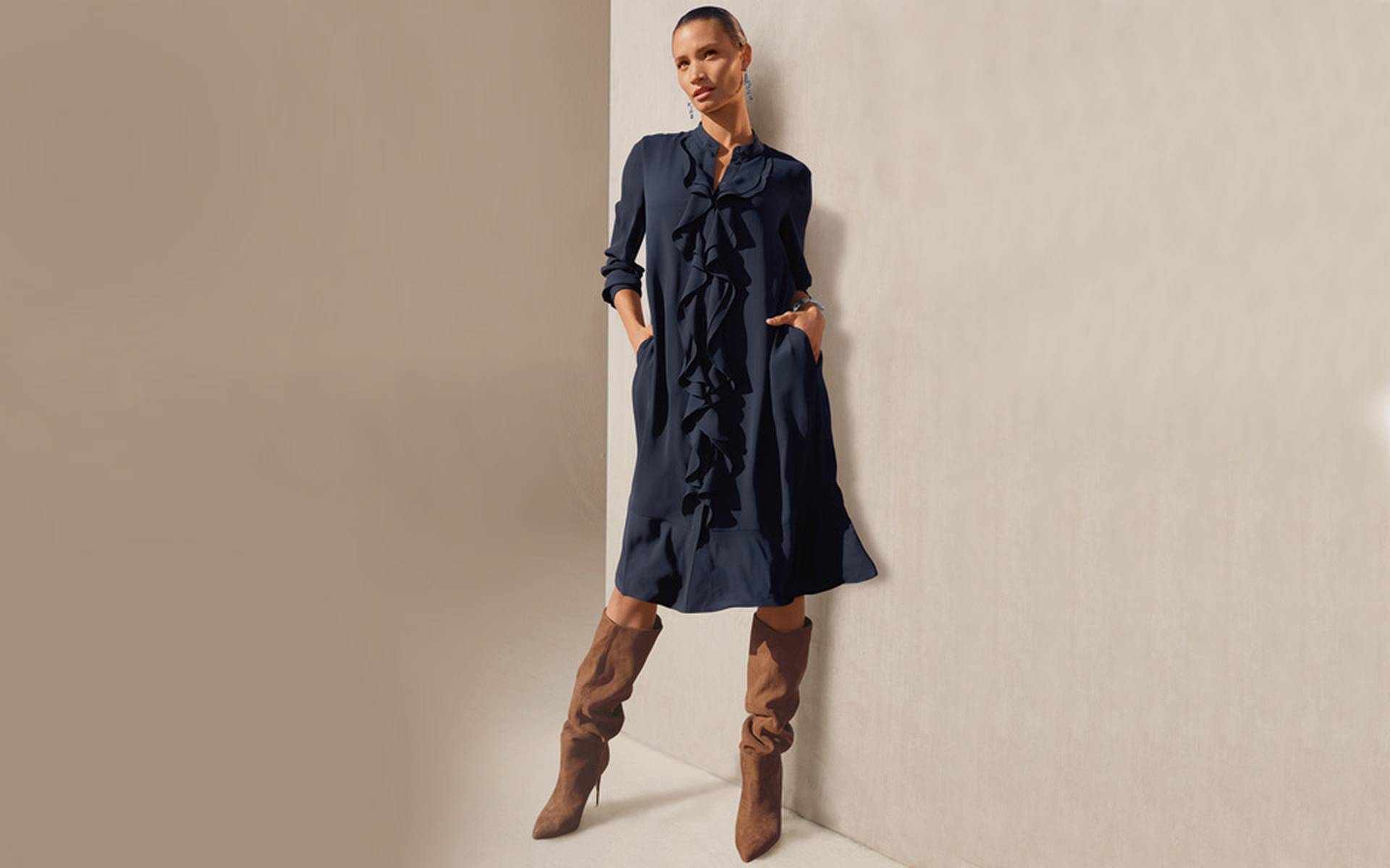 Navy shirt dress in a knee-length silhouette with cascading ruffles, a V-neckline and long sleeves.