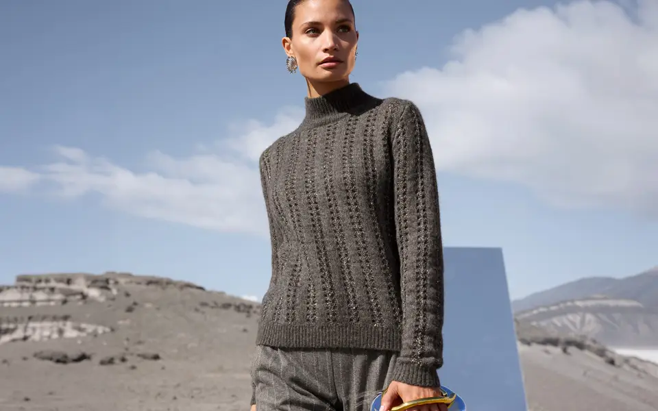 Maille ajourée et structurée sur un pull gris à col montant, manches longues et coupe droite.