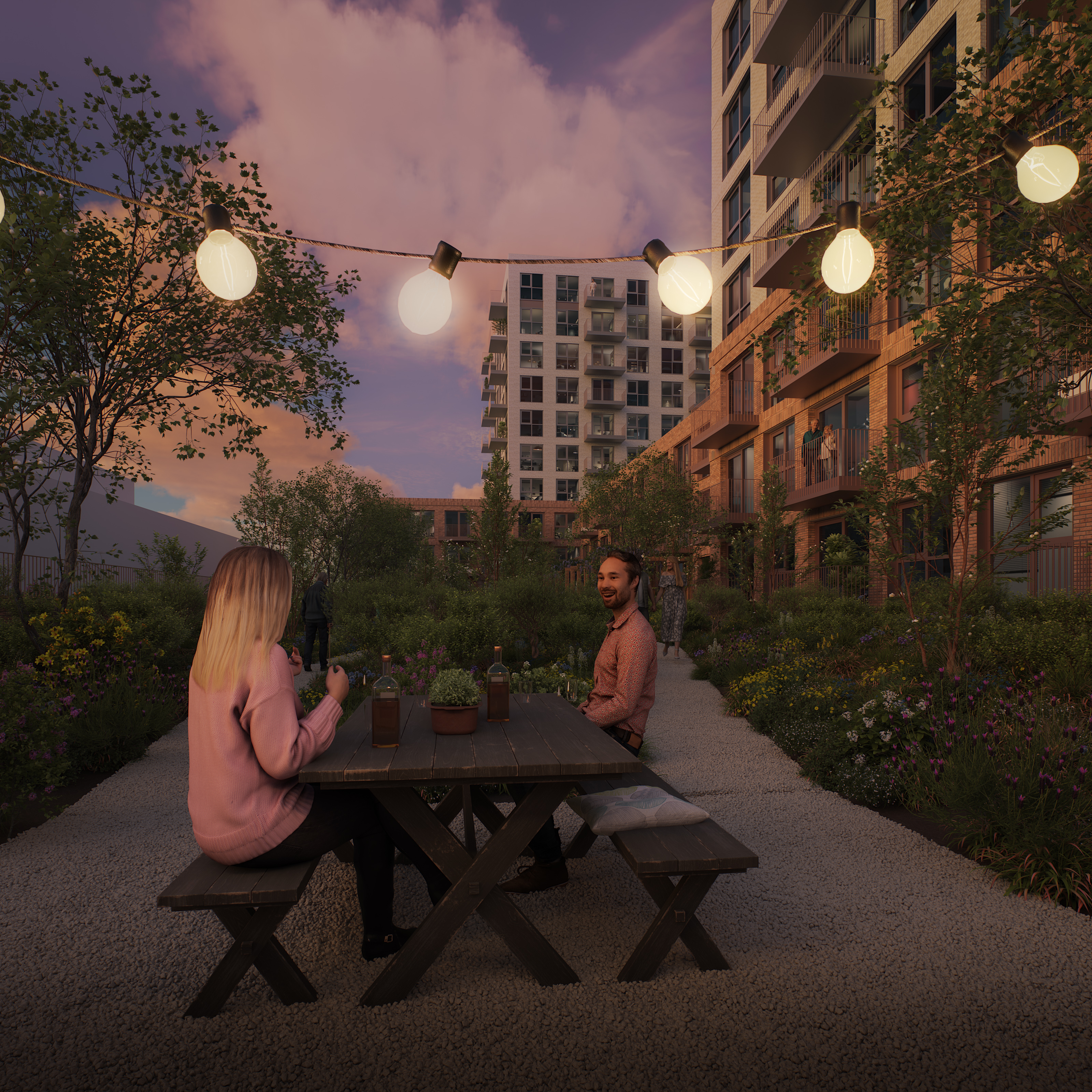 Dusk garden courtyard with glowing string lights; two people seated at a wooden picnic table beside modern apartment buildings.
