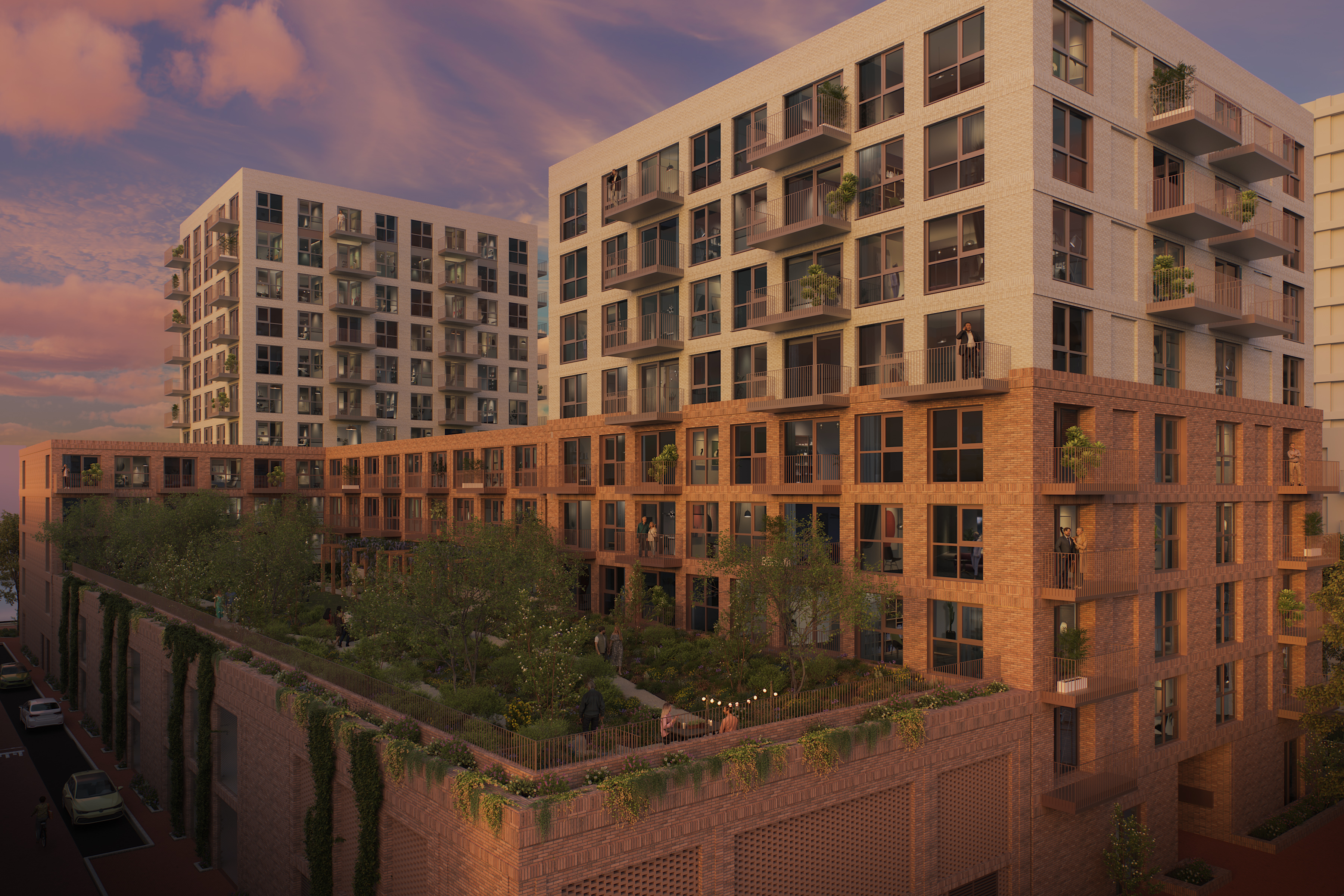 Sunset view of a modern apartment complex: brick lower blocks, light upper towers, balconies and a planted rooftop garden with people.