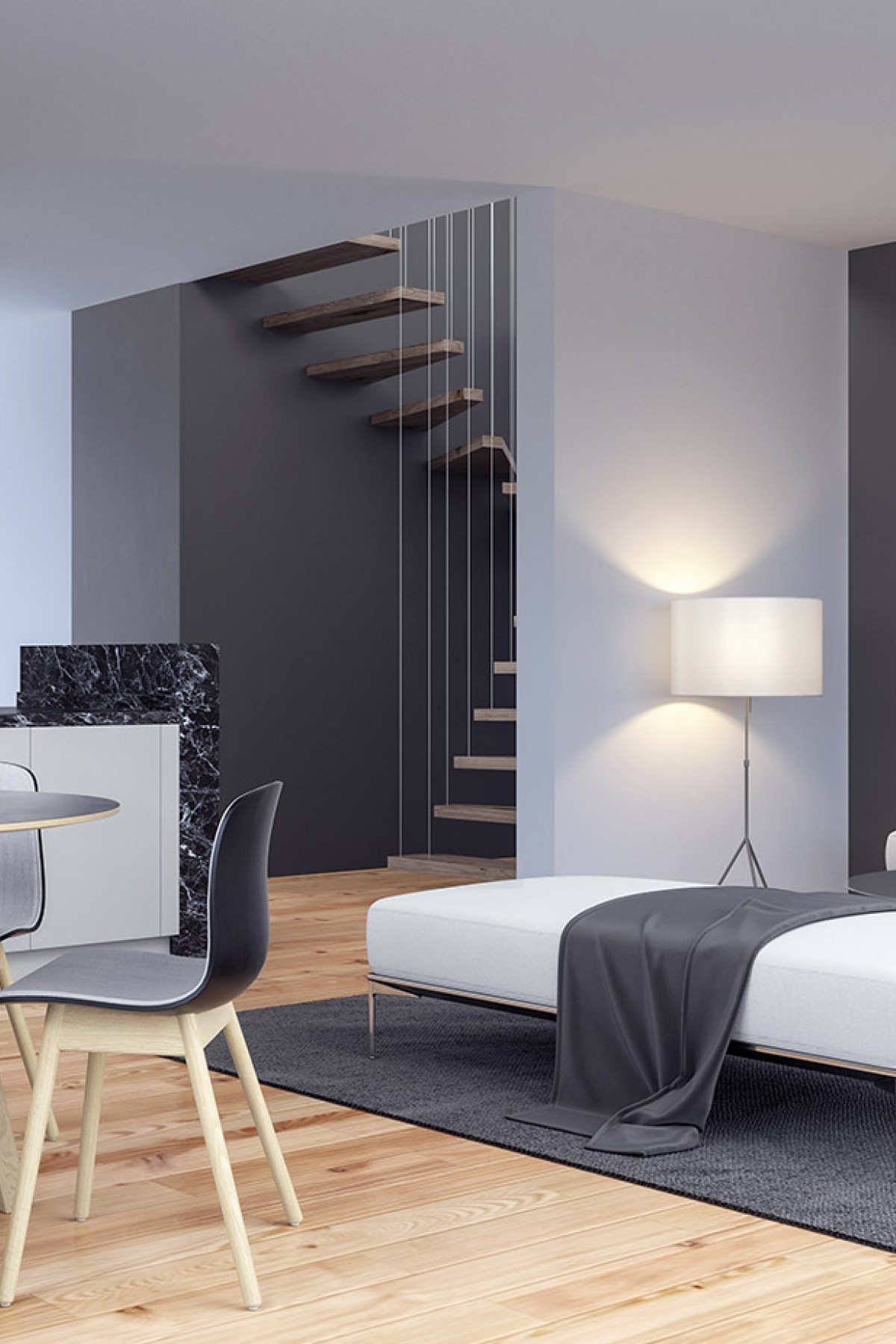 A modern bedroom with a white bed, gray rug, and wooden floor. A black chair and table are placed near the bed. A white lamp is placed on the right side of the bed. A wooden staircase is located behind the bed. A black marble wall is placed near the staircase. A white cabinet is placed on the left side of the room.