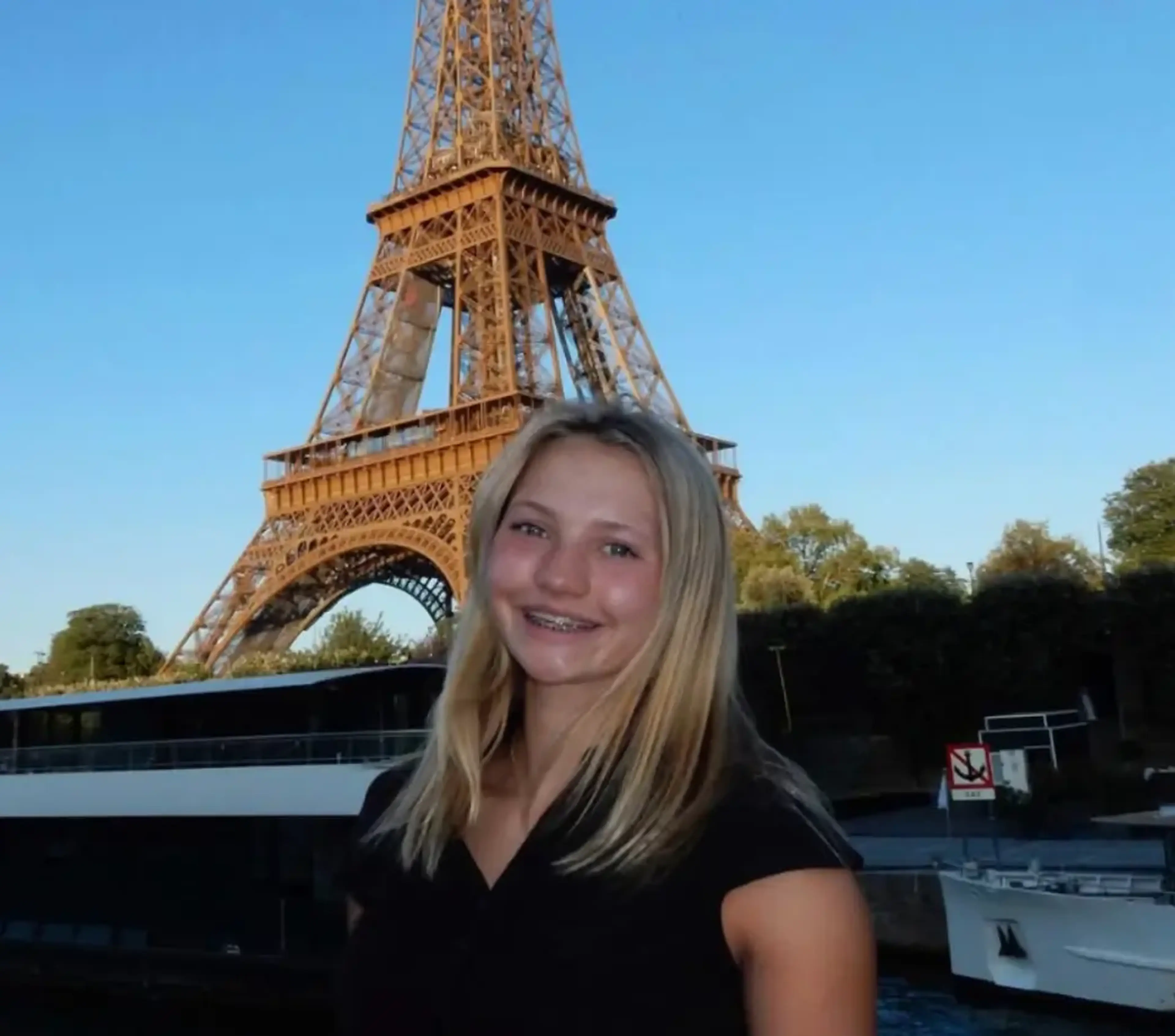 Student smiling in front of the Eiffel Tower in Paris