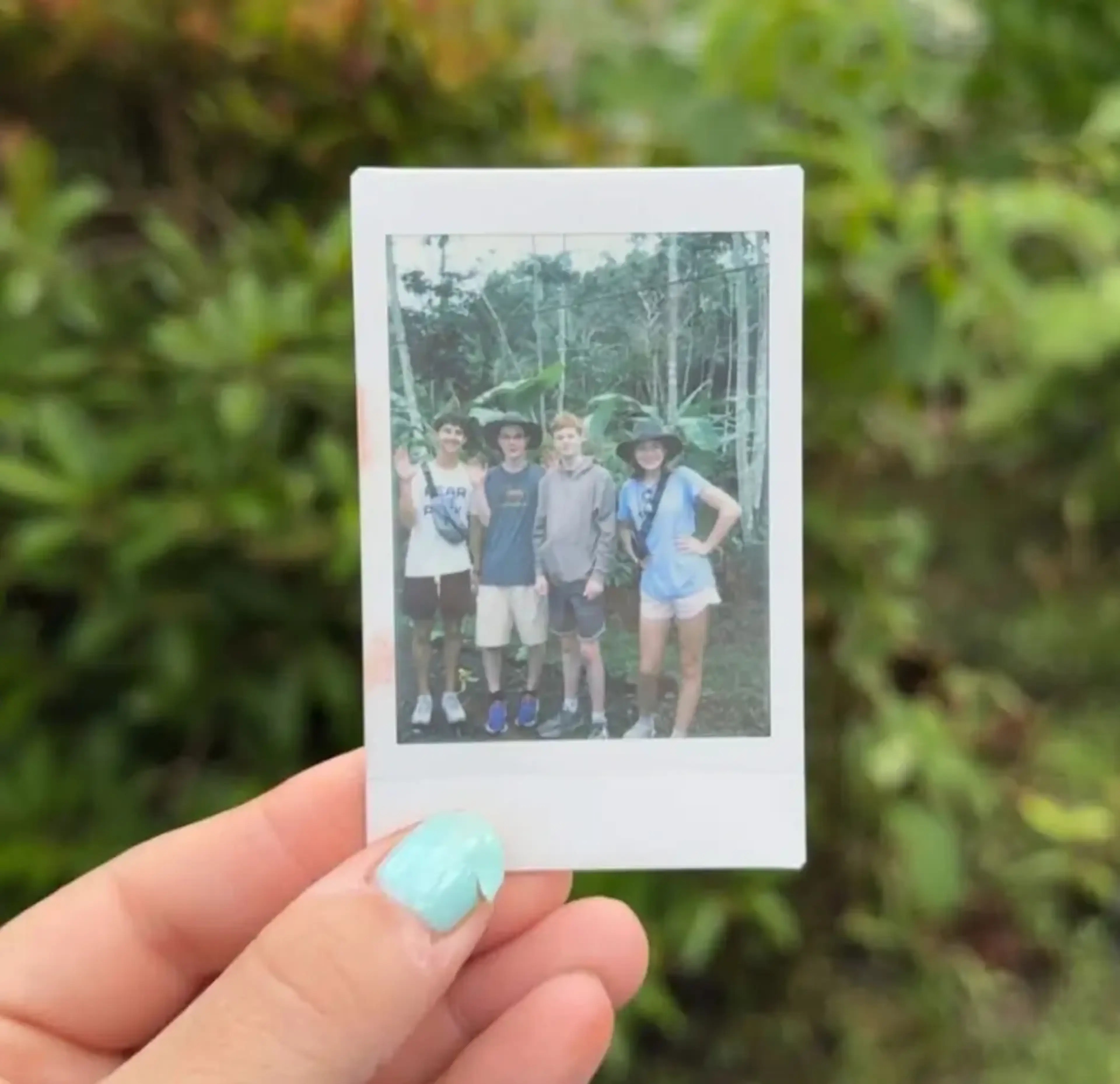 Student showing polaroid photo of friends in Costa Rica